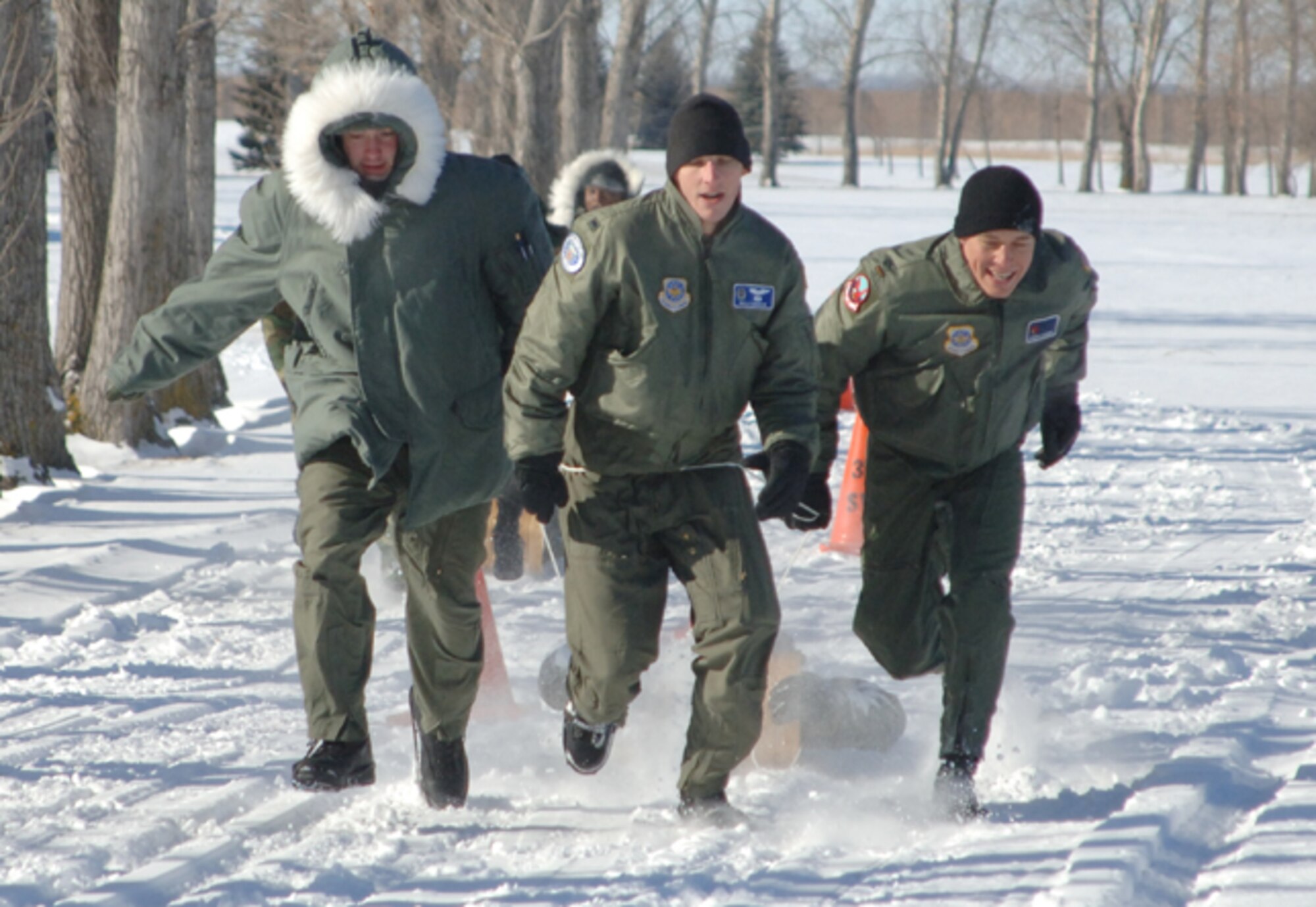 Team Grand Forks pulls ahead of their opponents in sub-zero weather during an esprit de corps event here Feb. 8 during the Tanker Winter Symposium.  The symposium was sponsored by the base to give active duty KC-135 crews and maintenance professionals throughout 18th Air Force a venue to discuss practices and develop new techniques to make aerial refueling more efficient and safe. More than 60 Airmen attended the event. (U.S. Air Force photo/Airman 1st Class Chad Kellum)