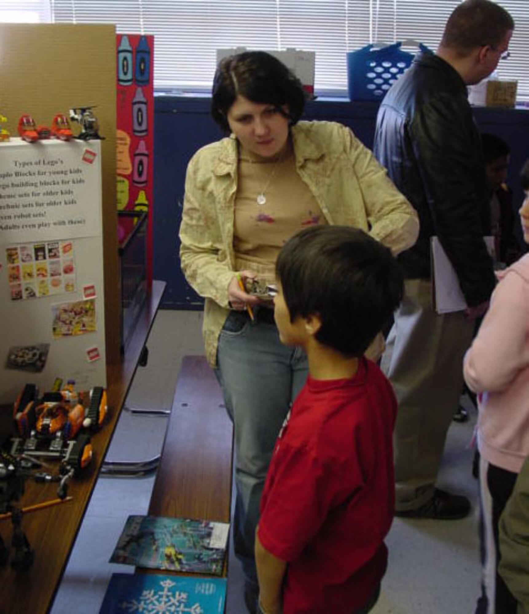 Staff Sgt. Sarah Rucker, 316th Training Squadron, asks Jarrol Bales (son of Tech Sgt. Kelly Bales) about his display. (U.S. Air Force photo by Tech. Sgt. Kelly Bales)