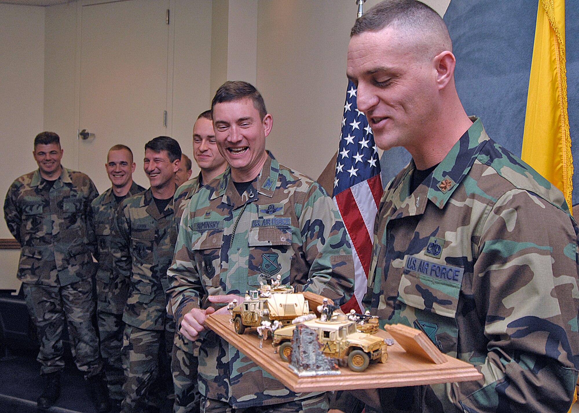 Maj. Tim Pertuis, right, 377th Logistics Readiness Squadron commander, presents Col. Robert E. Suminsby Jr., with a diorama of a deployed situation for the wing entry way display. The diorama depicts a Humvee break down during a convoy operation. It was built by Airman 1st Class David Wilson, who is deployed from the 377th LRS. Members of the squadron are behind the colonel.  (U.S. Air Force photo by Todd Berenger)