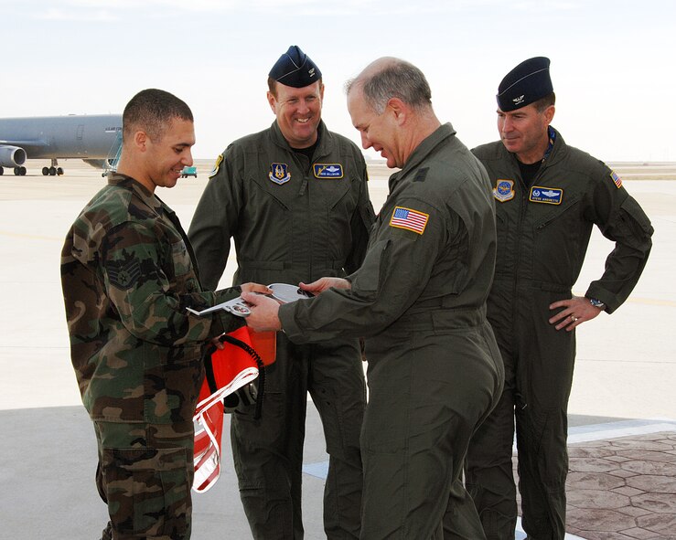 Maj. Gen. Ronald Ladnier, commander of the 18th Air Force Tanker Airlift Control Center, Scott Air Force Base, Ill., presents the "keys" to Travis' newest C-17 to Staff Sgt. Joshua Allen, 860th Aircraft Maintenance Squadron during an C-17 arrival ceremony Feb. 6. Observing the presentation are Col. Steven Arquiette, (right), 60th Air Mobility Wing commander and Col. Robert Millmann Jr., 349th Air Mobility Wing vice commander. (U.S. Air Force photo by David Cushman)