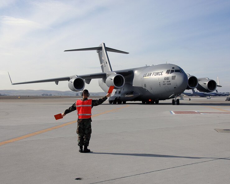 Staff Sgt. Joshua Allen, 860th Aircraft Maintenance Squadron, marshals Travis newest C-17 into it's parking place Feb. 6. Maj. Gen Ronald Ladnier, commander of the 18th Air Force Tanker Airlift Control Center, Scott Air Force Base, Ill. 
(U.S. Air Force photo by David Cushman)
