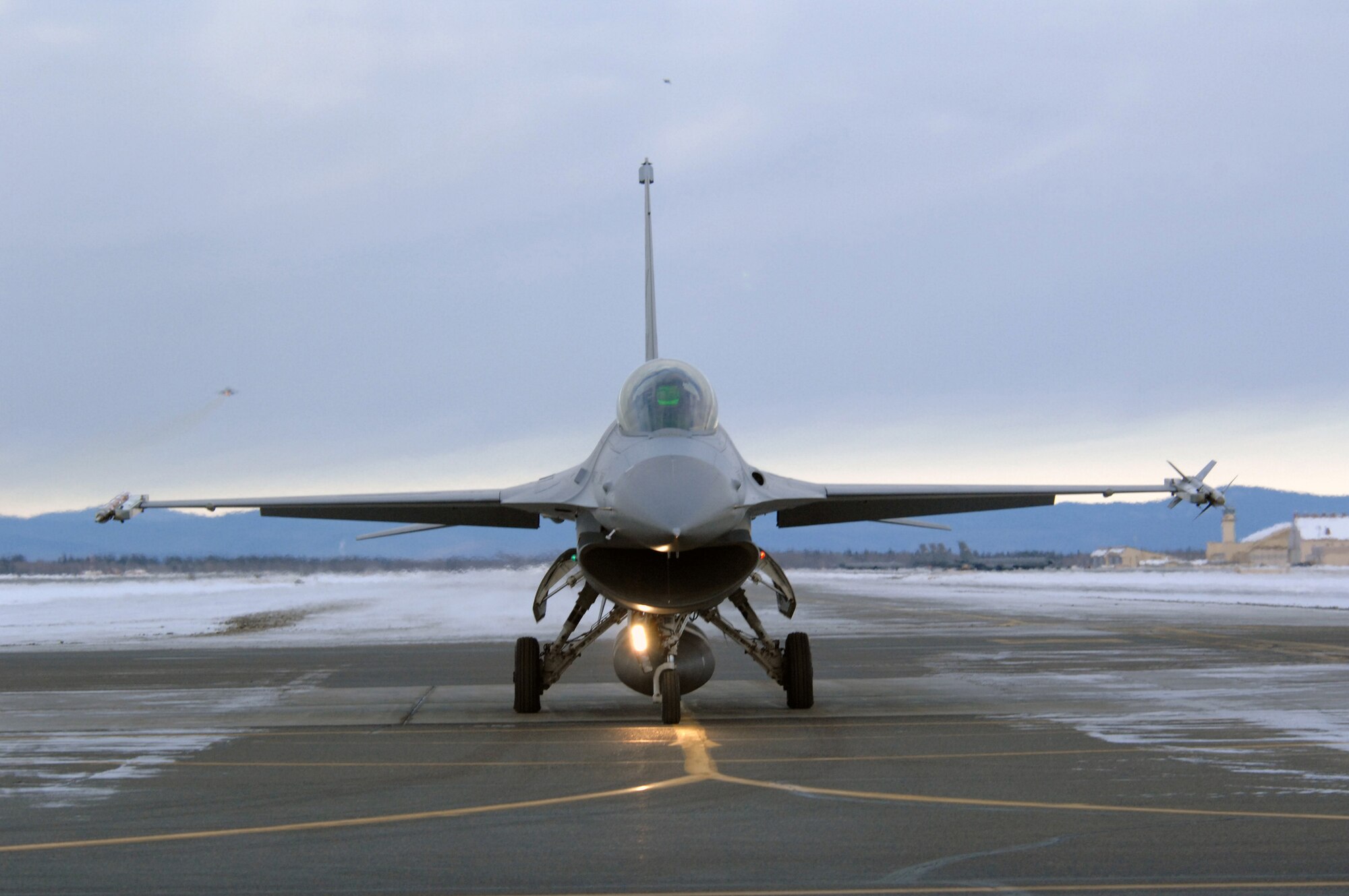 EIELSON AIR FORCE BASE, Alaska -- An F-16C Fighting Falcon aircraft from the 18th Fighter Squadron waits to taxi while two other F-16 aircraft take off in the background for training missions here on Feb.8. The 18th Fighter Squadron conducts air operations for combat-ready F-16 aircraft and provides close air support, forward air control (airborne), battlefield air interdiction, and offensive counter air.
(U.S. Air Force Photo by Staff Sgt Joshua Strang)