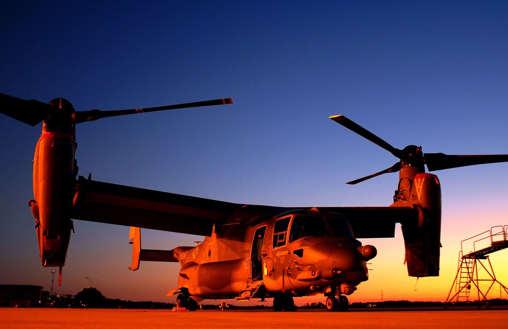 A CV-22 Osprey awaits its next mission on the ramp at Hurlburt Field, Fla.  The tilt-rotor Osprey, which has the speed of a conventional airplane and the ability to hover like a helicopter, gives warfighters the ability to perform missions that would otherwise require both fixed-wing and rotary-wing aircraft.  (U.S. Air Force photo/Chief Master Sgt. Gary Emery)
