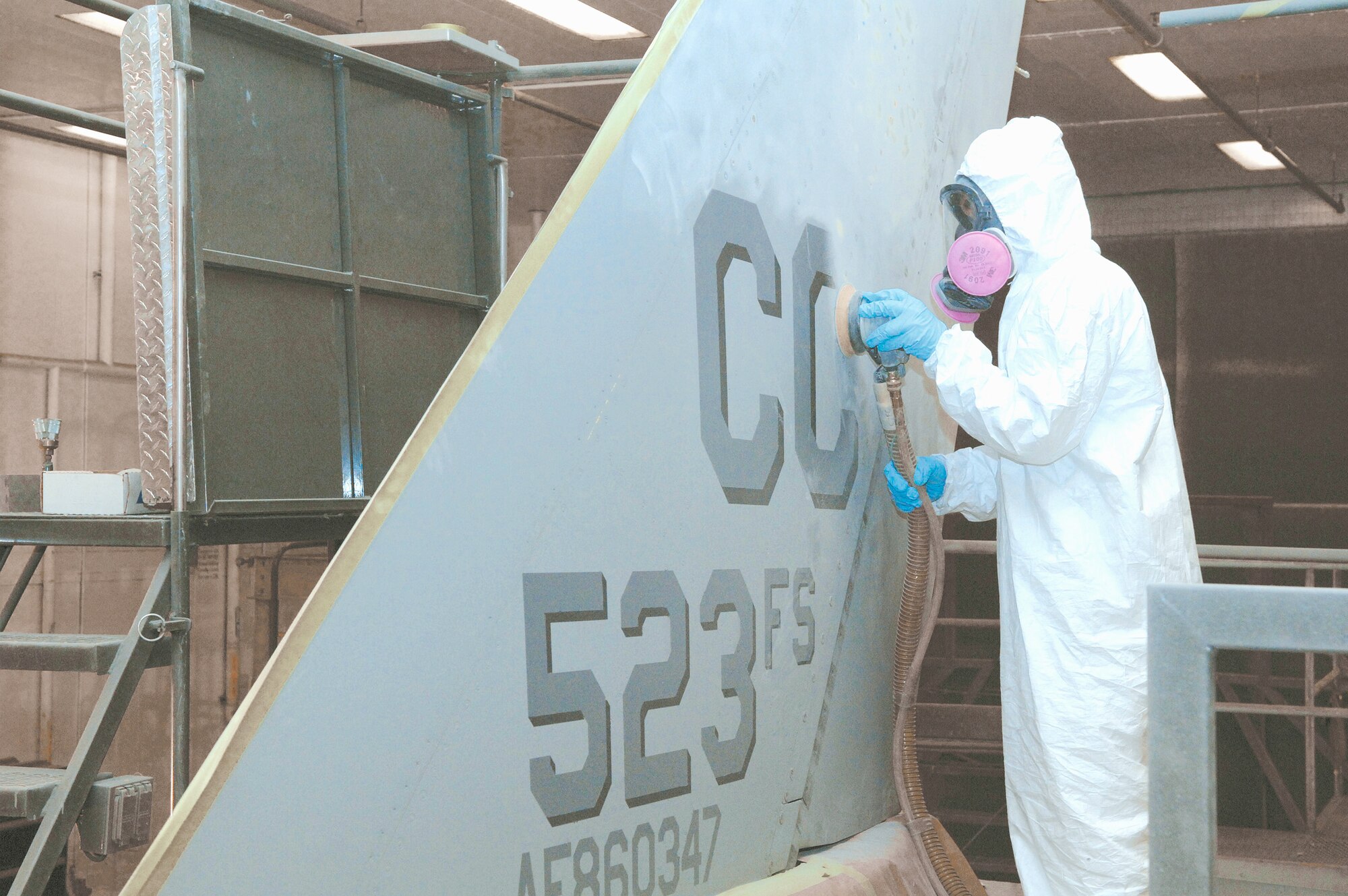 Airman 1st Class Harlyn Johnson, 27th Equipment Maintenance Squadron corrosion control at Cannon Air Force Base N. M., sands off the "CC" tail marking from a 523rd Fighter Squadron F-16 jet Feb. 5 to prepare it for its new home. The first two Cannon jets are destined for Des Monines Air Guard Station, Iowa. Though some jets are already gone and others will soon depart, the 27th Fighter Wing remains mission ready. 