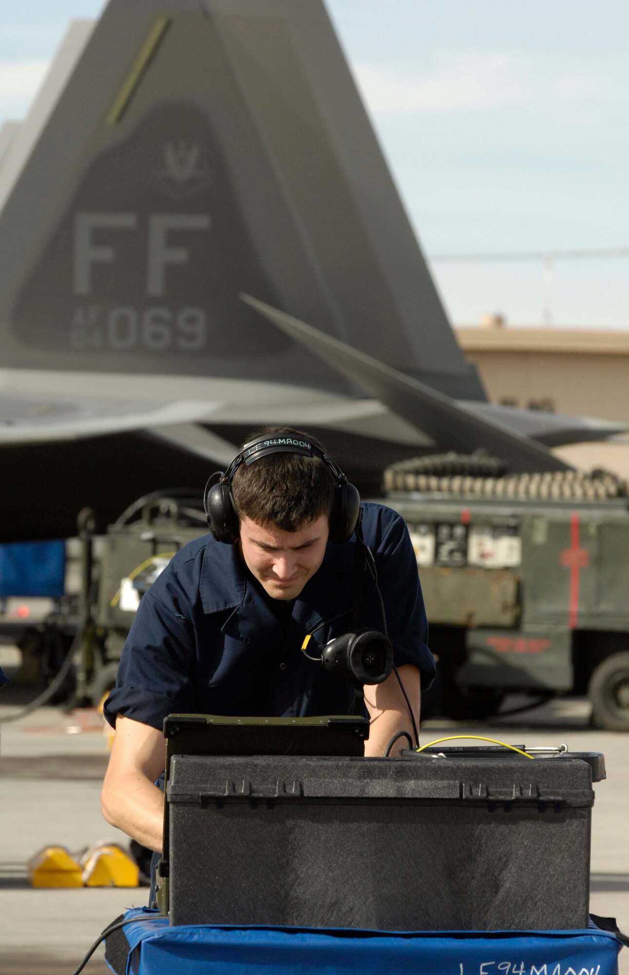 Airman 1st Class Adam Watson reviews F-22 Raptor data on a portable maintenance aid during Red Flag 07-02 Feb. 6 at Nellis Air Force Base, Nev. Red Flag sharpens aircrews' warfighting skills in realistic combat situations. The F-22s will be flying missions during the day and night to the nearby Nevada Test and Training Range where they will simulate an air war. The Air Force and Navy, along with military forces from Australia and the United Kingdom, are participating in Red Flag. Airman Watson is a tactical aircraft maintenance specialist with the 94th Fighter Squadron at Langley Air Force Base, Va. This is the first deployment to Red Flag for the 94th FS with the F-22. (U.S. Air Force photo/Master. Sgt. Kevin J. Gruenwald) 
