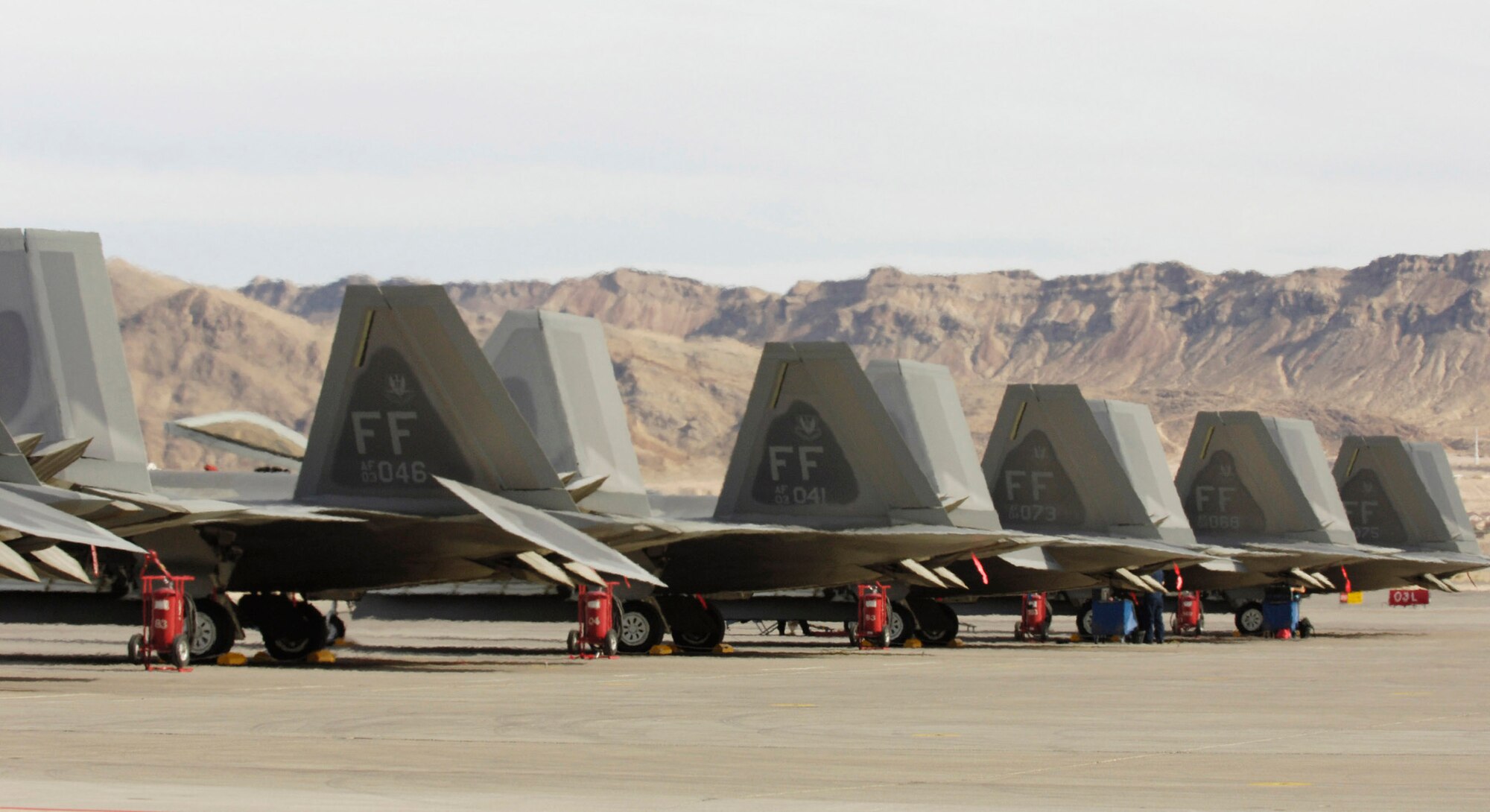 F-22 Raptors are parked on the flightline during Red Flag 07-02 Feb. 6 at Nellis Air Force Base, Nev. Red Flag sharpens aircrews' warfighting skills in realistic combat situations. The aircraft from 94th Fighter Squadron of Langley Air Force Base in Virginia will be flying missions during the day and night to the nearby Nevada Test and Training Range where they will simulate an air war. The Air Force and Navy, along with military forces from Australia and the United Kingdom, are participating in Red Flag. This is the first deployment to Red Flag for the 94th FS with F-22. (U.S. Air Force photo/Master. Sgt. Kevin J. Gruenwald)
