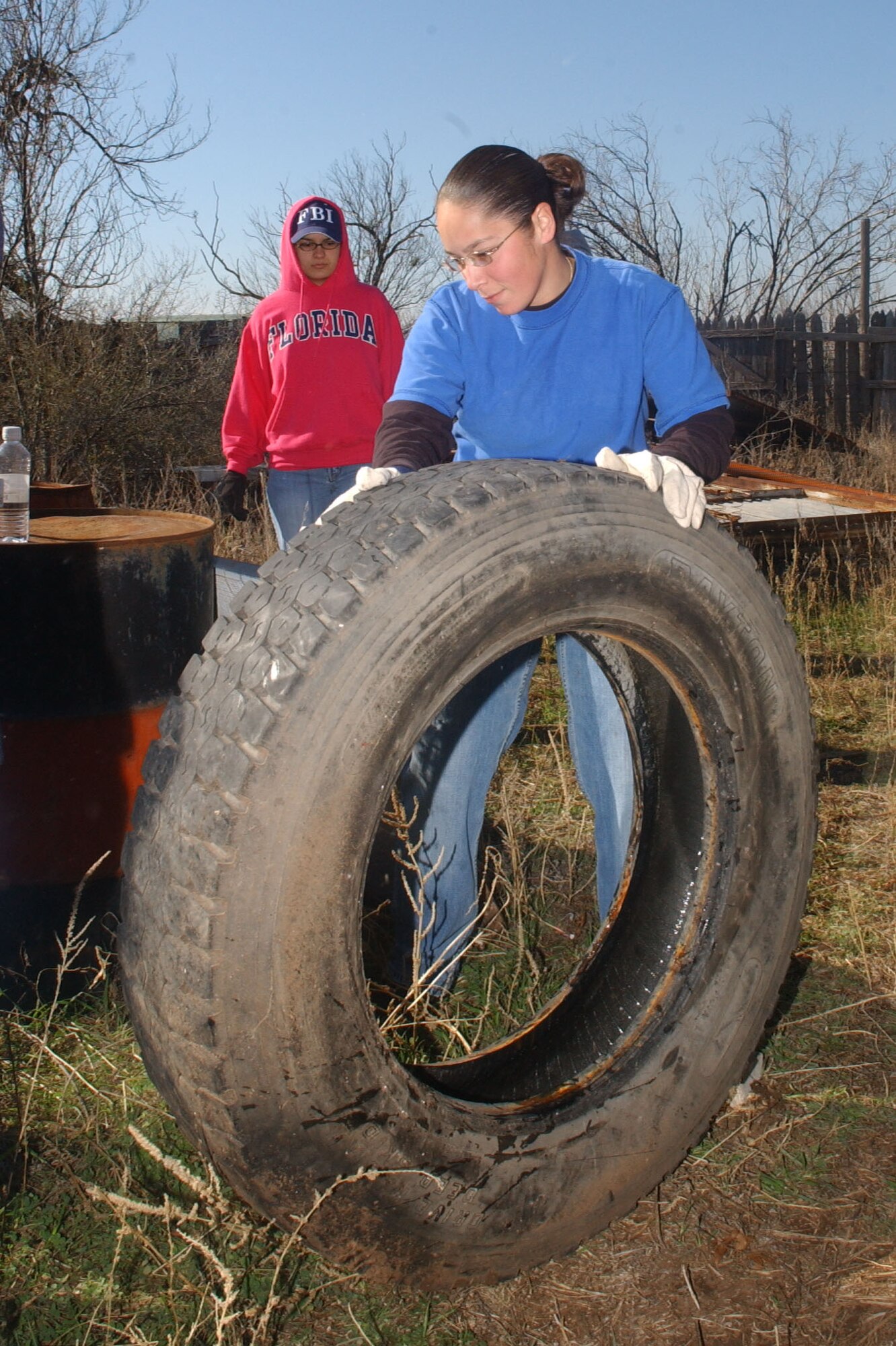 Senior Airman Diana Klesel rolls a large tire out of the way. (U.S. Air Force photo by Staff Sgt. Gina O’Bryan)