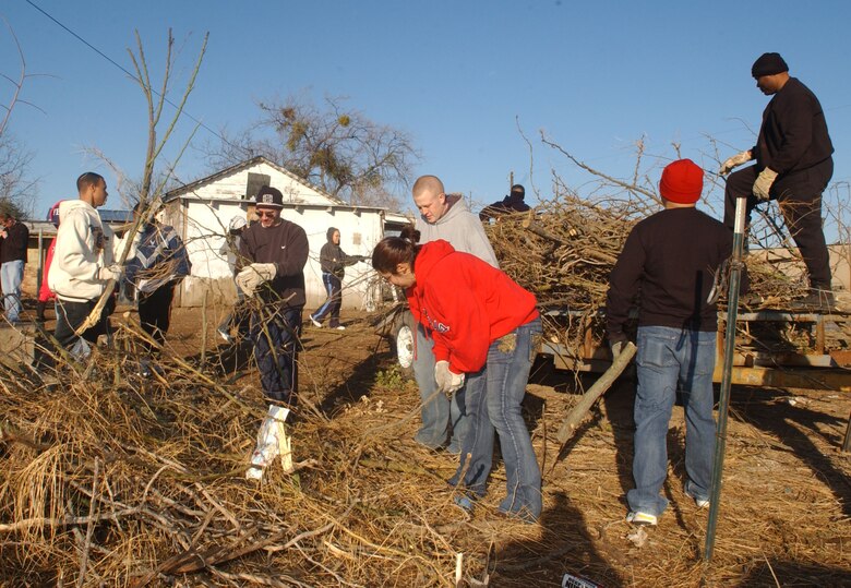 Permanent party and technical school students from Goodfellow work together to load up a flat-bed trailer with brush from one of six lots from homes of elderly or disabled residents in San Angelo. (U.S. Air Force photo by Staff Sgt. Gina O’Bryan)
