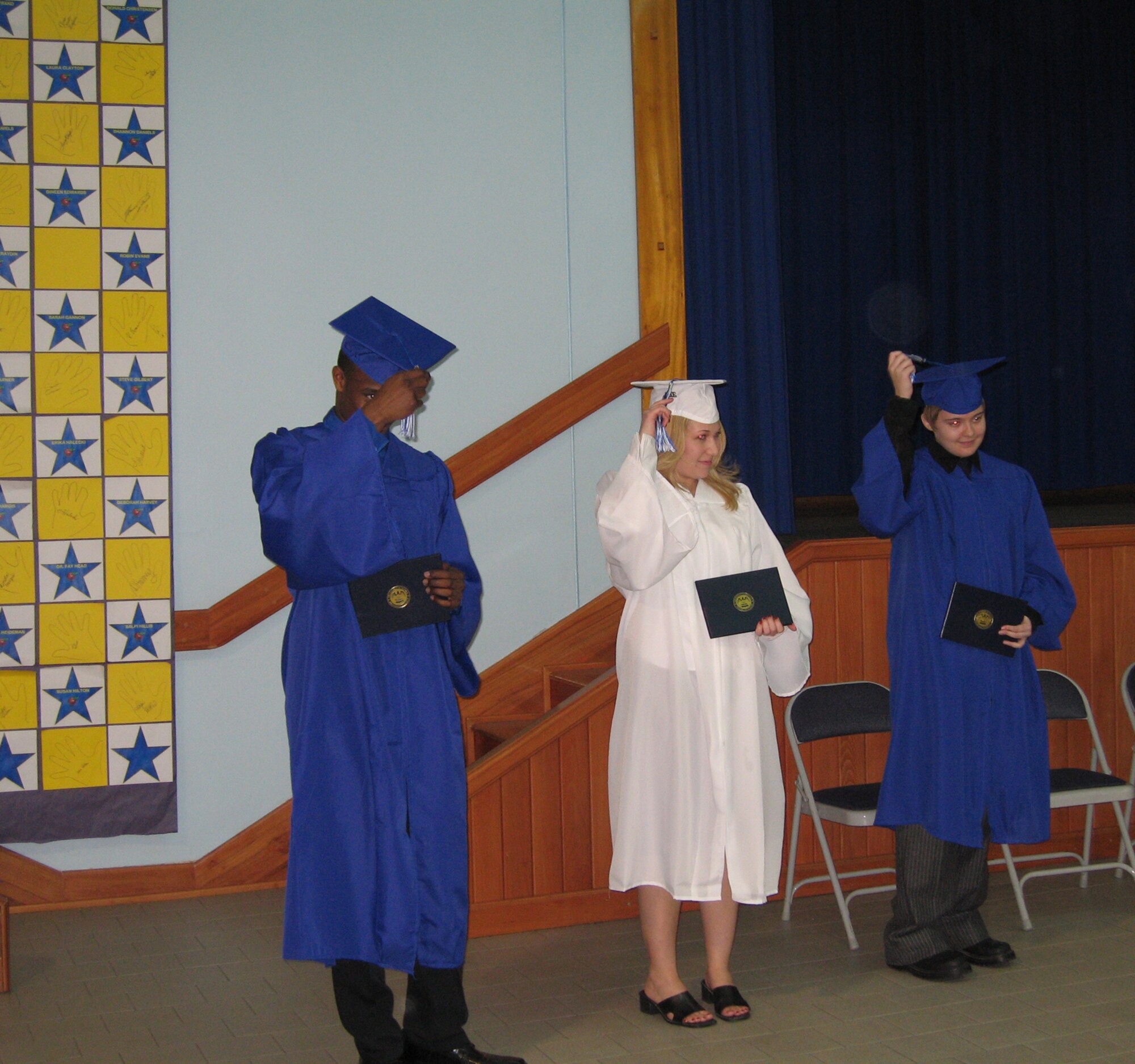 Jeffrey Douglas McWaine, (left), Nicole Marie Smith, (middle), and Kristen Lynn Stamper move their tassles to the left after receiving their diplomas during their mid-year commencement ceremony Feb. 7. The students credited their family, teachers, and friends for their achievement. (U.S. Air Force photo by Senior Airman Patrice Clarke)