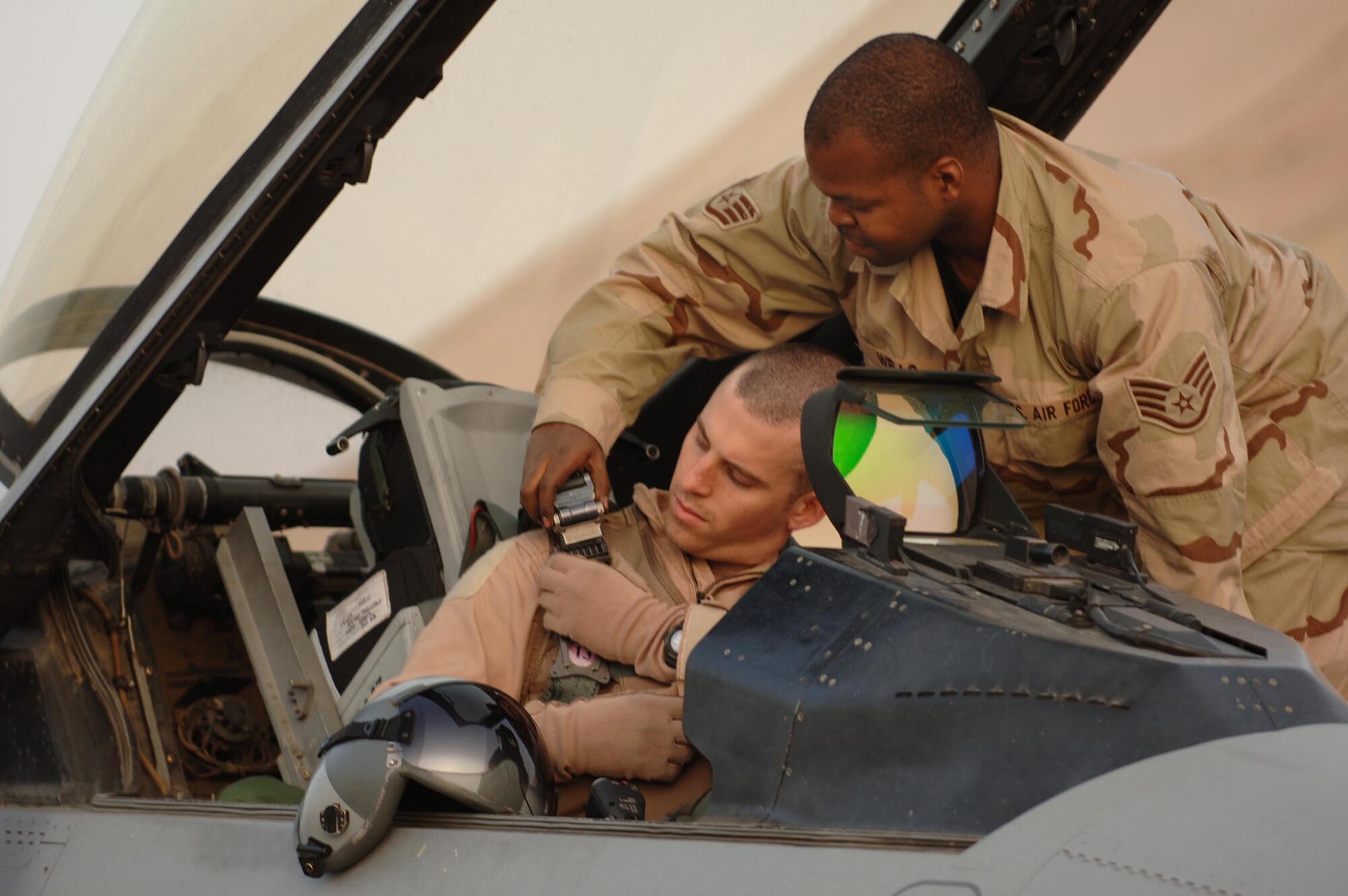 Staff Sgt. Christian Wells, 510th Expeditionary Aircraft Maintenance Squadron, helps Capt. Wyatt Morrise, 510th Expeditionary Fighter Squadron, get strapped into an F-16 before a combat mission at Balad Air Base, Iraq. Captain Morrise and Sergeant Wells are deployed from Aviano to the 332nd Air Expeditionary Wing. (Photo by Staff Sgt. Michael Holzworth)
