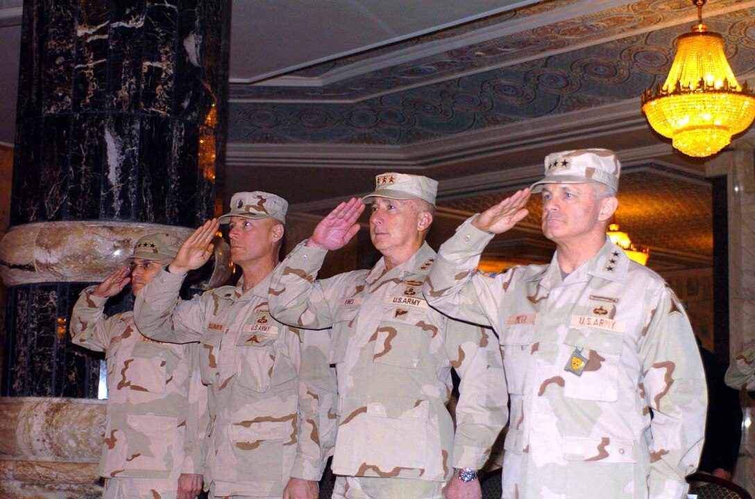 From the left: Army Gen. George W. Casey, Jr., commander,  Multinational Force Iraq; Command Sgt. Maj. Jeffrey J. Mellinger, MNFI sergeant  major; Lt. Gen. John R. Vines, commander, Multinational Corps; and Lt. Gen.  Thomas F. Metz, former MNCI commander, salute the colors during the singing of  the national anthem during the transfer-of-authority ceremony between 18th  Airborne and 3rd Corps at Al-Faw Palace, Camp Victory, Iraq, Feb. 10. (Photo by  Sgt. Mark St.Clair, USA)