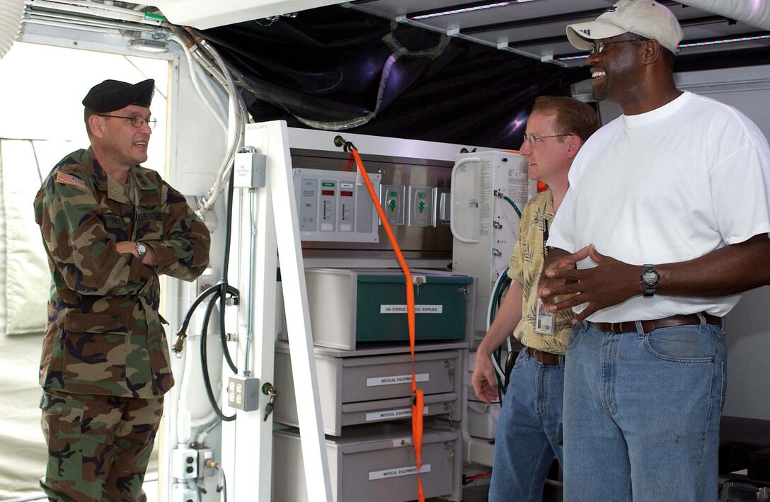 Army Maj. Gen. Lester Martinez-Lopez, commander of the U.S. 
Army Medical Research and Materiel Command and Fort Detrick, Md., visits the 
prototype of the Army's Future Medical Shelter System May 26 and speaks with 
Steve Reichard, center, and Tony Story about its future. Photo by Dave 
Rolls