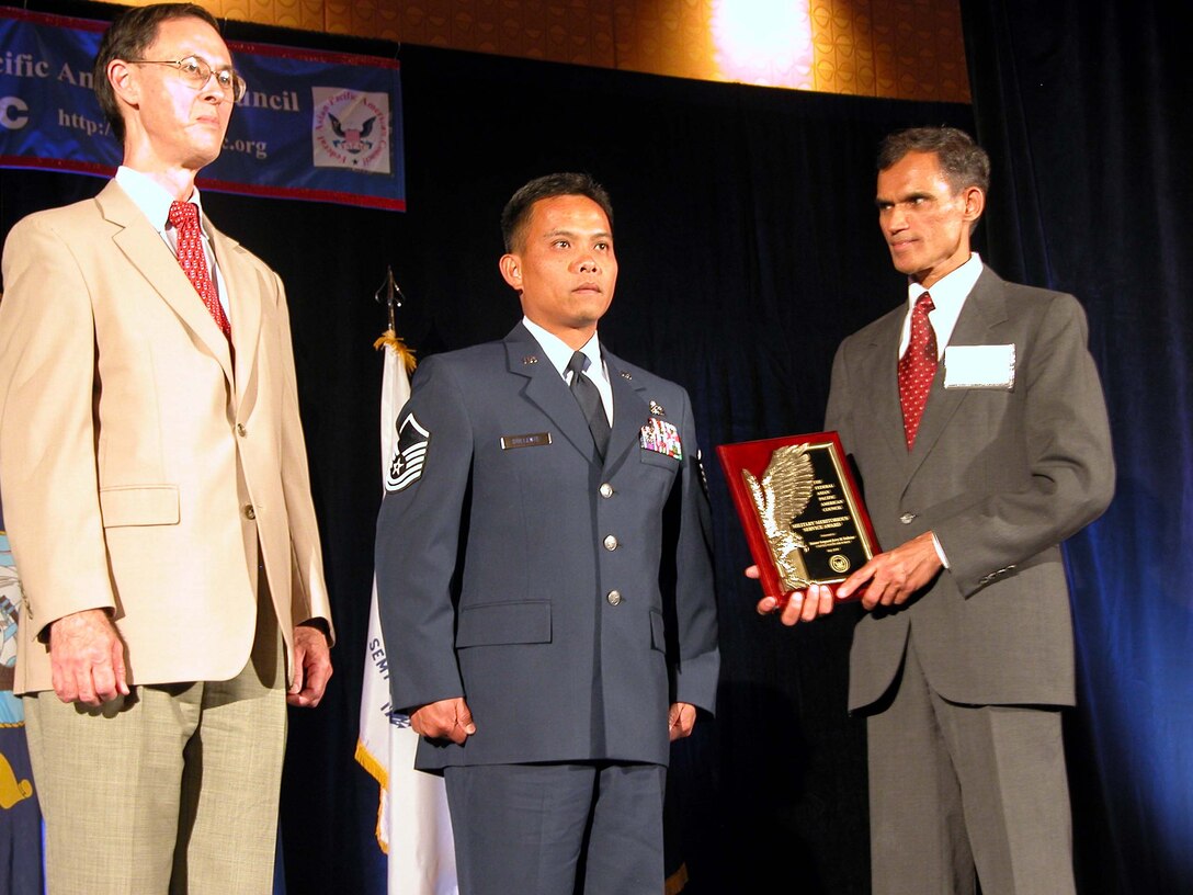 David S.C. Chu, right, undersecretary of defense for personnel and readiness, 
and Federal Asian Pacific American Council president Krupakar B. Revanna present Air Force 
Master Sgt. Jerry M. Dollente, with a meritorious service award for his efforts to promote 
cultural diversity at Travis Air Force Base, Calif. Dollente is an information systems manager 
with the 615th Air Mobility Squadron and also serves as president of the Asian-Pacific-Islanders 
Council at Travis. The award presentation took place during Asian-Pacific American Heritage 
month ceremonies in San Francisco May 19. The event was co-hosted by the DoD and the Federal 
Asian Pacific American Council. Photo by Sgt. 1st Class Doug Sample.