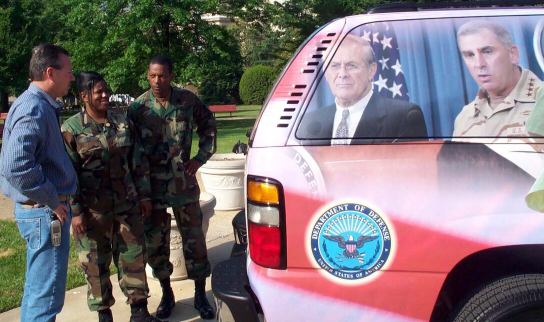 Ed Negrin discusses his trucks' red, white and blue design 
theme with Air Force Master Sgt. Cassandra White and Army Master Sgt. Bruce 
Allen May 14 in the Pentagon's center courtyard. Negrin and his wife, Tonie, 
were at the Pentagon with two of their decorated trucks to show support for 
U.S. service members. The trucks feature photos of service members, as well as 
Defense Secretary Donald H. Rumsfeld; Army Gen. John Abizaid, head of U.S. 
Central Command; other military leaders and President Bush. Photo by Gerry J. 
Gilmore