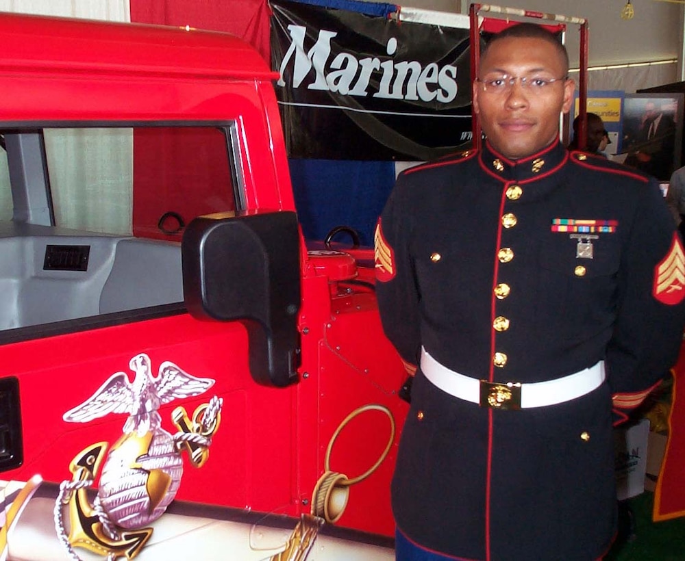 Attired in his dress blue uniform, Marine recruiter Sgt. Jeffery  Warner stands in front of a fire-engine-red Humvee boasting the Marine Corps'  logo May 6 at the Public Service Recognition Week exposition on the National  Mall in Washington. Photo by Gerry J. Gilmore