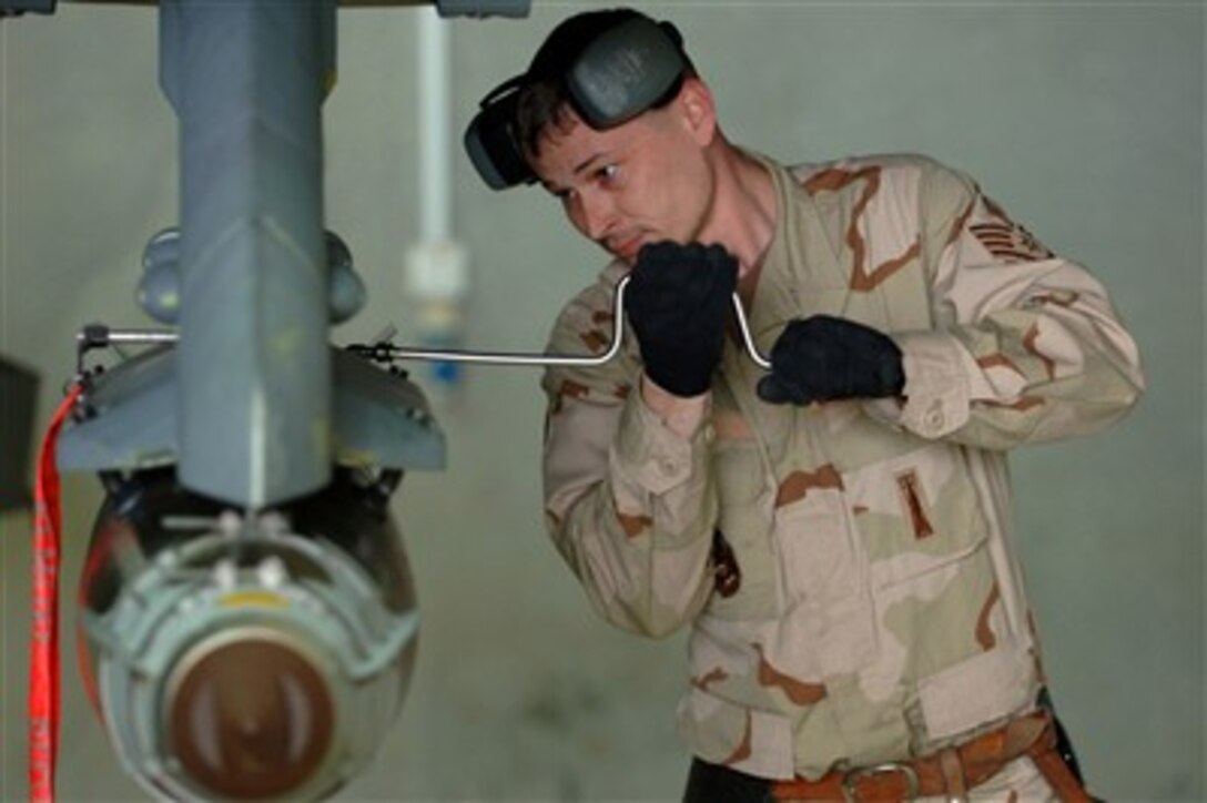 U.S. Air Force Staff Sgt. Steven Socia uses a speed wrench to secure a Joint Direct Attack Munition missile onto an F-16 Fighting Falcon aircraft at Balad Air Base, Iraq, on Feb. 7, 2007.  Socia is part of a weapons load crew assigned to the 332nd Expeditionary Aircraft Maintenance Squadron.  