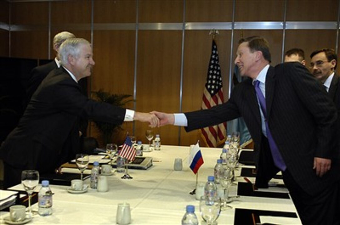 Secretary of Defense Robert Gates (left) and Russian Minister of Defense Sergey Ivanov reach across the conference table to greet each other before beginning a bilateral meeting at the NATO Defense Ministerial in Seville, Spain, on Feb. 8, 2007.  Gates and other NATO defense ministers are meeting informally in Seville to freely discuss key issues concerning the alliance.  