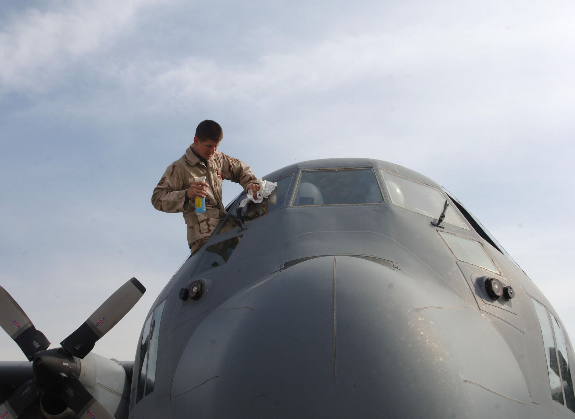 Tech. Sgt. Myles Debshaw, a 455th Expeditionary Aircraft Maintenance Squadron crew chief, cleans the windshield of a C-130 Hercules. Sergeant Myles works for the Illinois Air National Guard full time and is on his second deployment. (U.S. Air Force photo/Staff Sgt. Kevin Tomko)