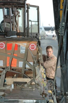 Airman 1st Class Brian Mulkey, 746th Expeditionary Airlift Squadron loadmaster, marshals in palletized cargo onto a C-130H for a tactical airlift mission. (U.S. Air Force photo by Senior Airman Erik Hofmeyer)