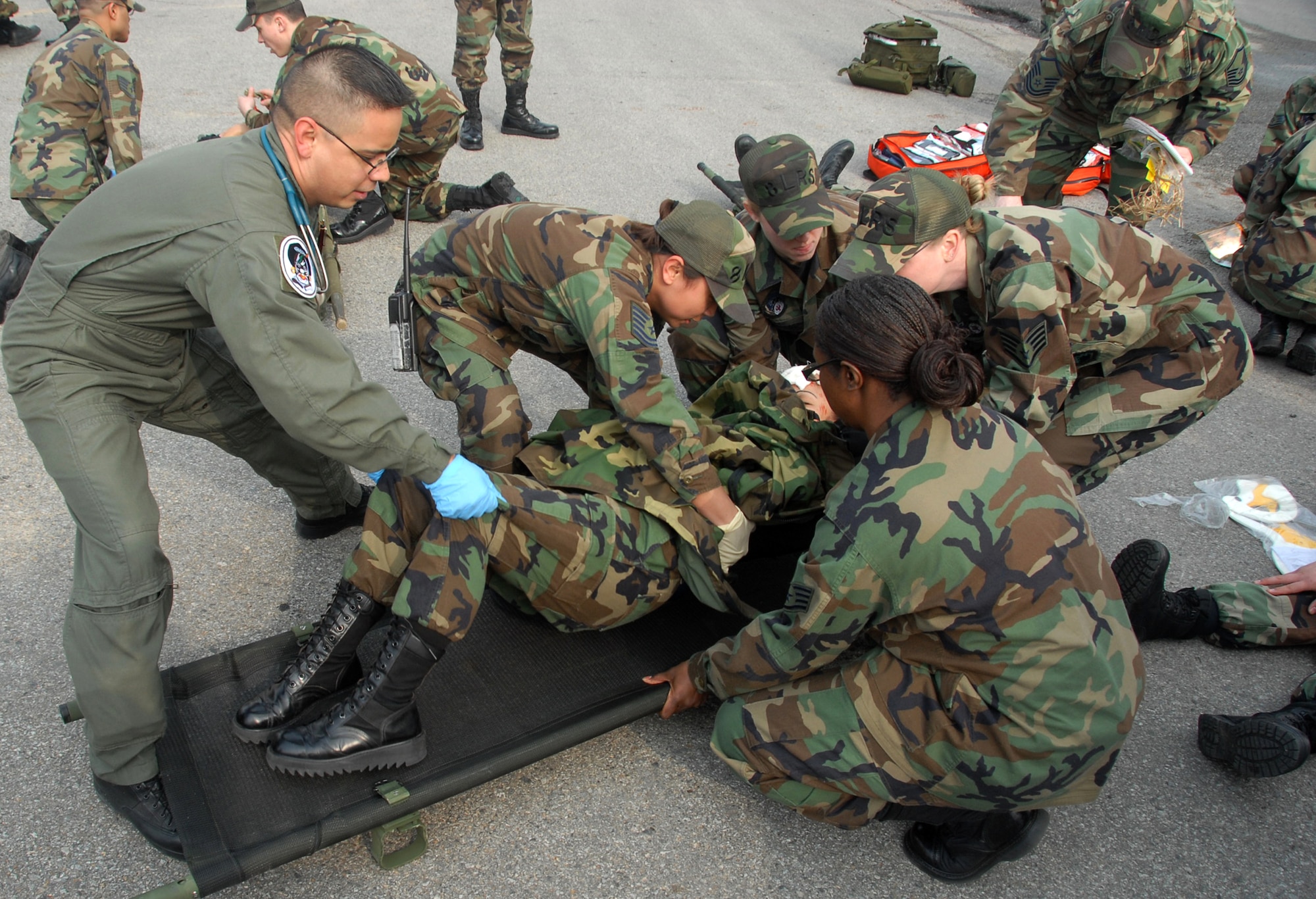 Members of the 8th Fighter Wing disaster response team place a simulated victim on a stretcher Feb. 9 during a major accident response exercise at Kunsan Air Base, South Korea. The accident, designed to provide realistic training for emergency response teams, simulated a major vehicle accident with multiple victims. (U.S. Air Force photo/Tech Sgt. Jeffrey A. Wolfe)