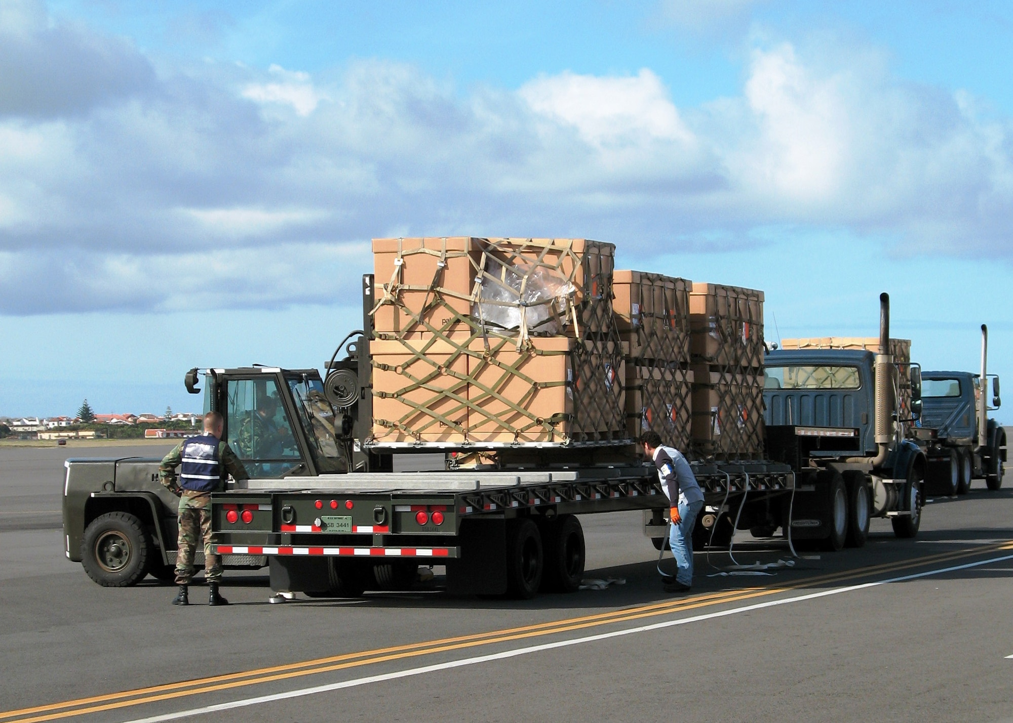 Air transportation specialists tie down a load to a truck headed to the base commissary Feb. 7 at Lajes Field, Azores. These pallets traveled from Germany on a 747 to Lajes Field carrying goods for the commissary and base exchange. (U.S. Air Force photo/Airman Caitlin Putman)