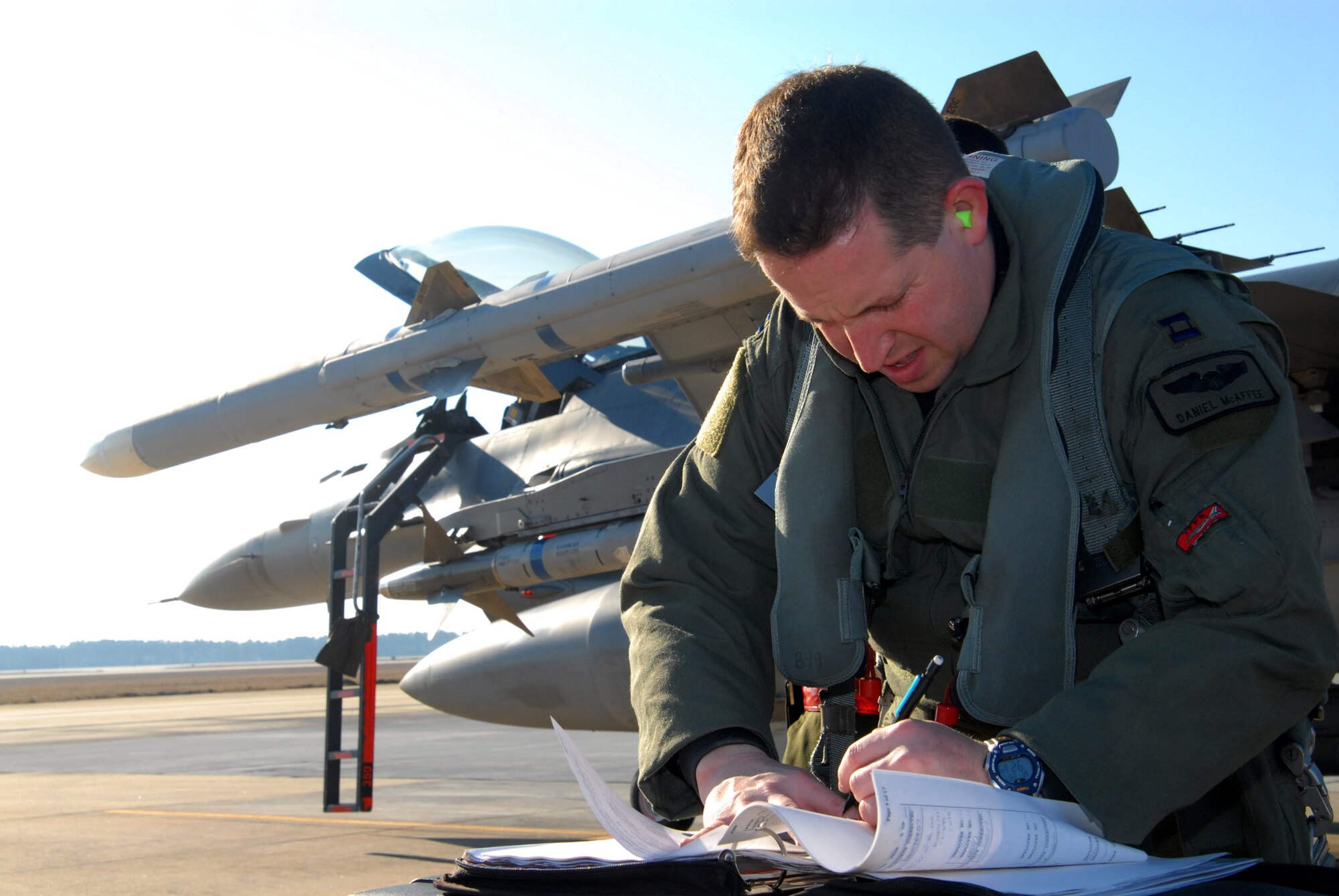 Capt Daniel McAffee annotates flight logs before piloting an F-16 Fighting Falcon in support of Exercise Iron Thunder  Feb. 7 at Shaw Air Force Base, S.C. The objective of the exercise is to prepare units for future contingency operations by offering a chance for players to be exposed to missions identical to those faced in combat. Captain McAffee is a 77th Fighter Squadron pilot. (U.S. Air Force photo/Tech. Sgt. James W. Arrowood)