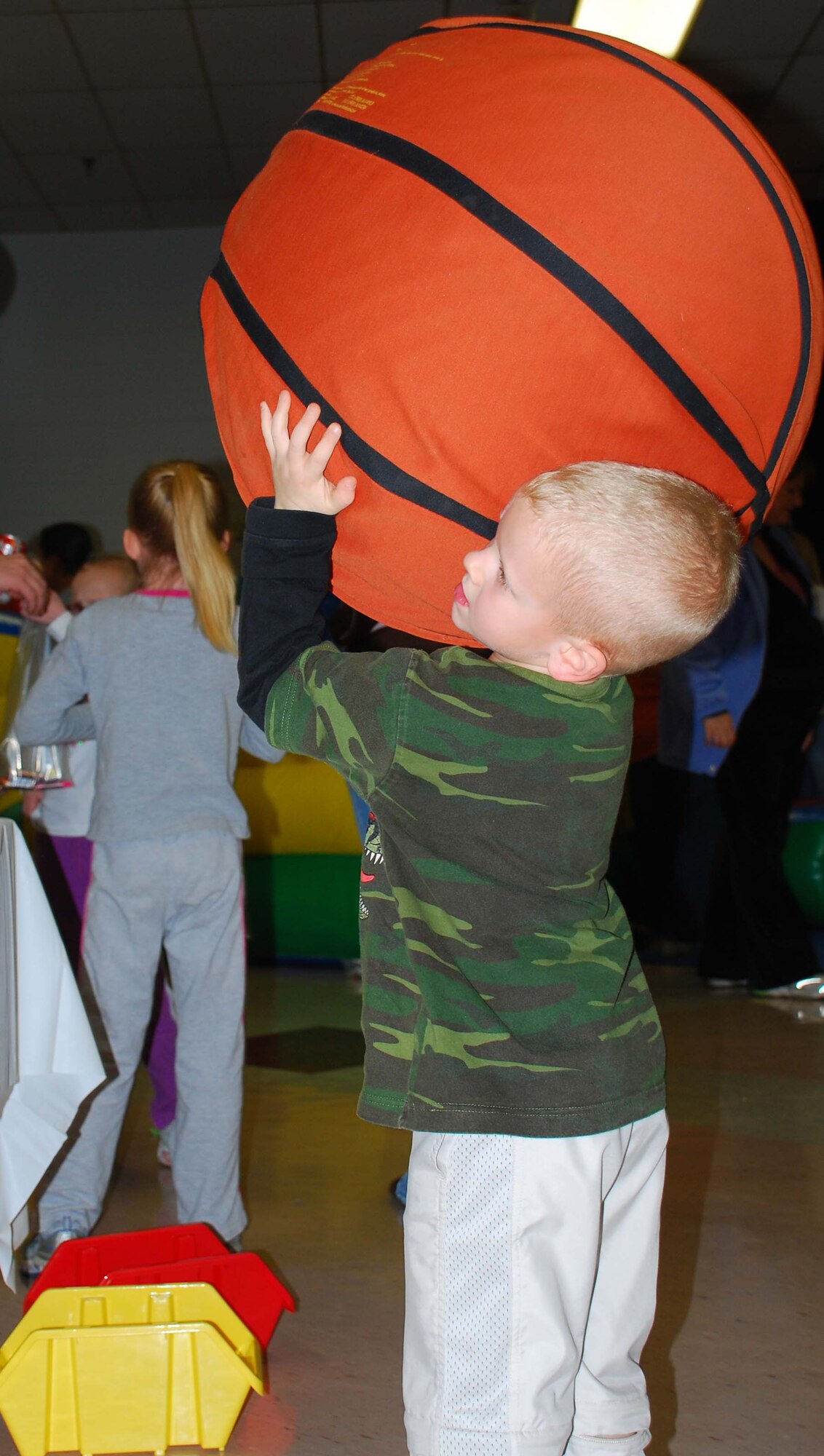 Caleb Zerkus lines up to take a shot at the Monster Basketball hoop Feb. 10 during the Gary Michael Holloway Military Housing Carnival. GMH sponsored the free event at the Community Center from 1-5 p.m. for the base housing residents. (U.S. Air Force photo/Tech. Sgt. Jennifer Isom) 