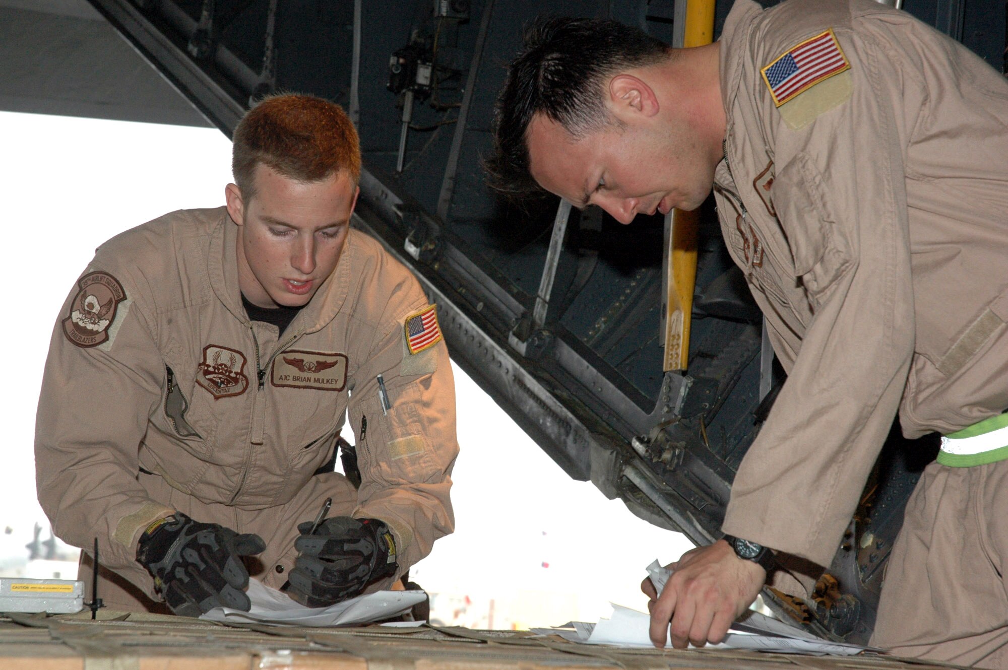 Airman 1st Class Brian Mulkey and Master Sgt. James McElwee sign paperwork after loading a pallet of cargo Feb. 8 in Southwest Asia. The two loadmasters are assigned to the 746th Expeditionary Airlift Squadron. (U.S. Air Force photo/Senior Airman Erik Hofmeyer) 
