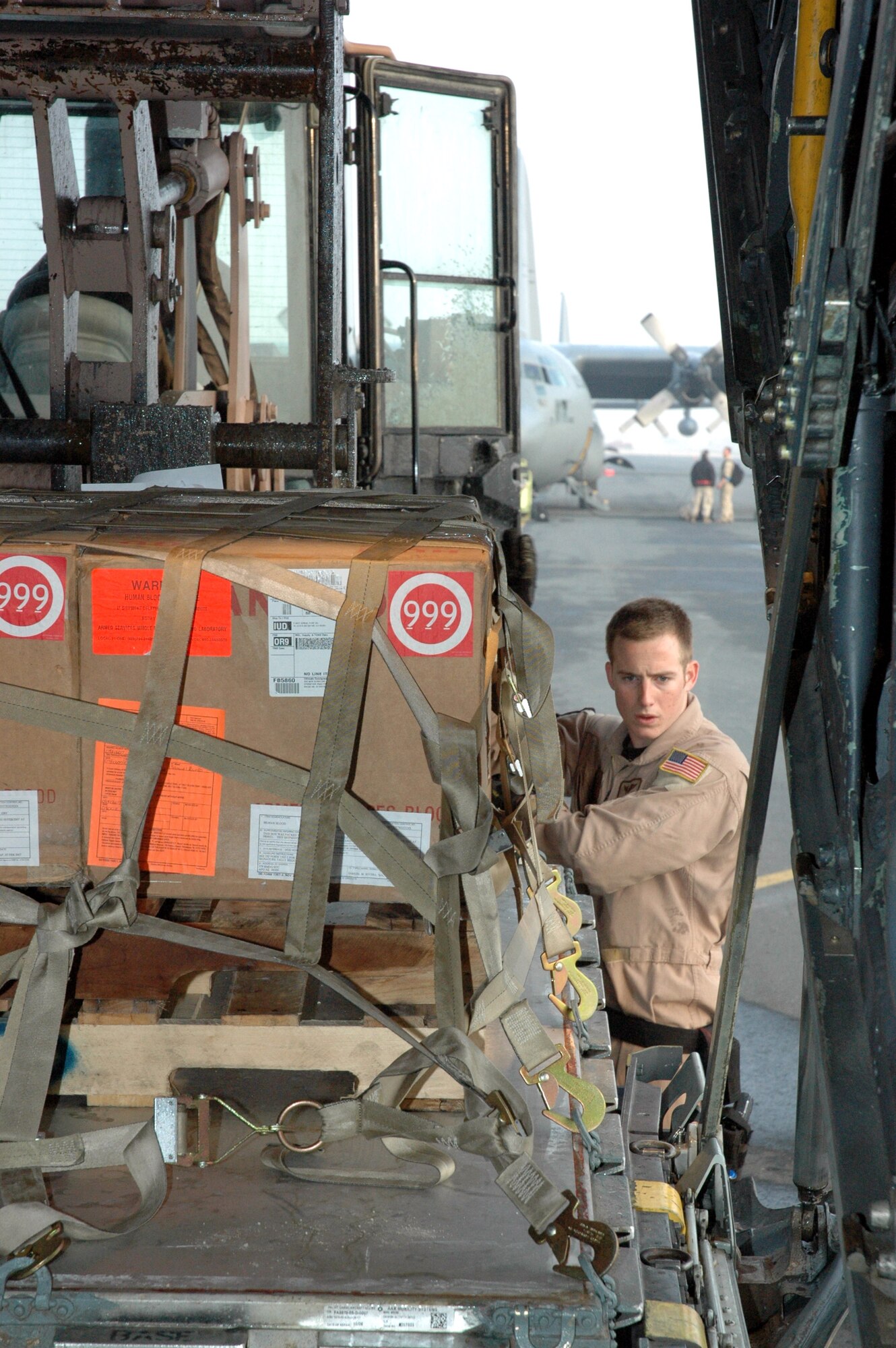 Airman 1st Class Brian Mulkey marshals in palletized cargo onto a C-130 Hercules for a tactical airlift mission Feb. 8 in Southwest Asia. Airman Mulkey is a loadmaster assigned to the 746th Expeditionary Airlift Squadron. (U.S. Air Force photo/Senior Airman Erik Hofmeyer) 
