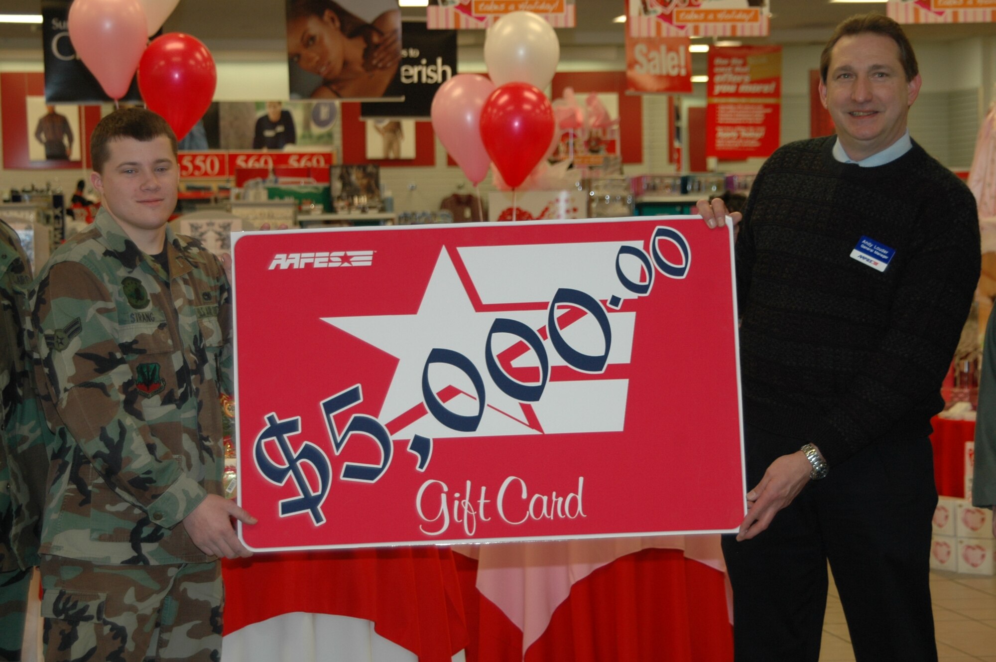 Airman 1st Class Kyle Strang, 28th Maintenance Squadron aerospace propulsion journeyman, receives a $5,000 Army and Air Force Exchange Service shopping spree from manager, Andy Louder.
Airman Strang entered the After Thanksgiving Shopping Spree Sweepstakes at the Ellsworth Base Exchange. All AAFES locations drew only one name and forwarded it to AAFES headquarters in Dallas for the final drawing. Airman Strang is one of only 10 winners worldwide. (U.S. Air Force photo/Airman 1st Class Kimberly Moore Limrick)
