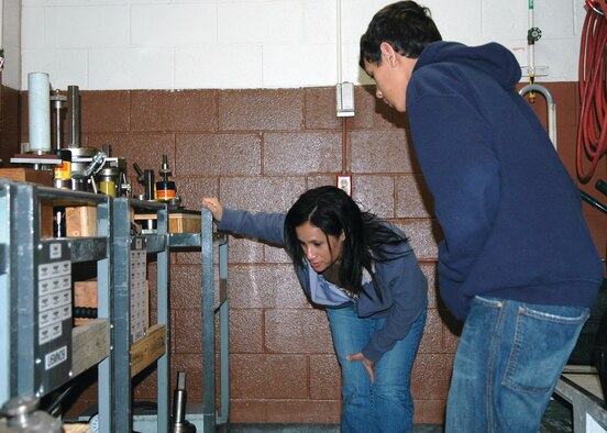 Dona Guillen, a master sergeant and material expediter, 917th Propulsion Flight, shows her son, Brandon, around her work area as part of Junior Achiement Groundhog Job Shadowing Day, Friday, Feb. 2 at the 917th Wing, Barksdale AFB, La. Brandon is an eighth-grade student at Elm Grove Middle School, Elm Grove, La.  (U.S. Air Force photo/Tech. Sgt. Jeff Walston)
