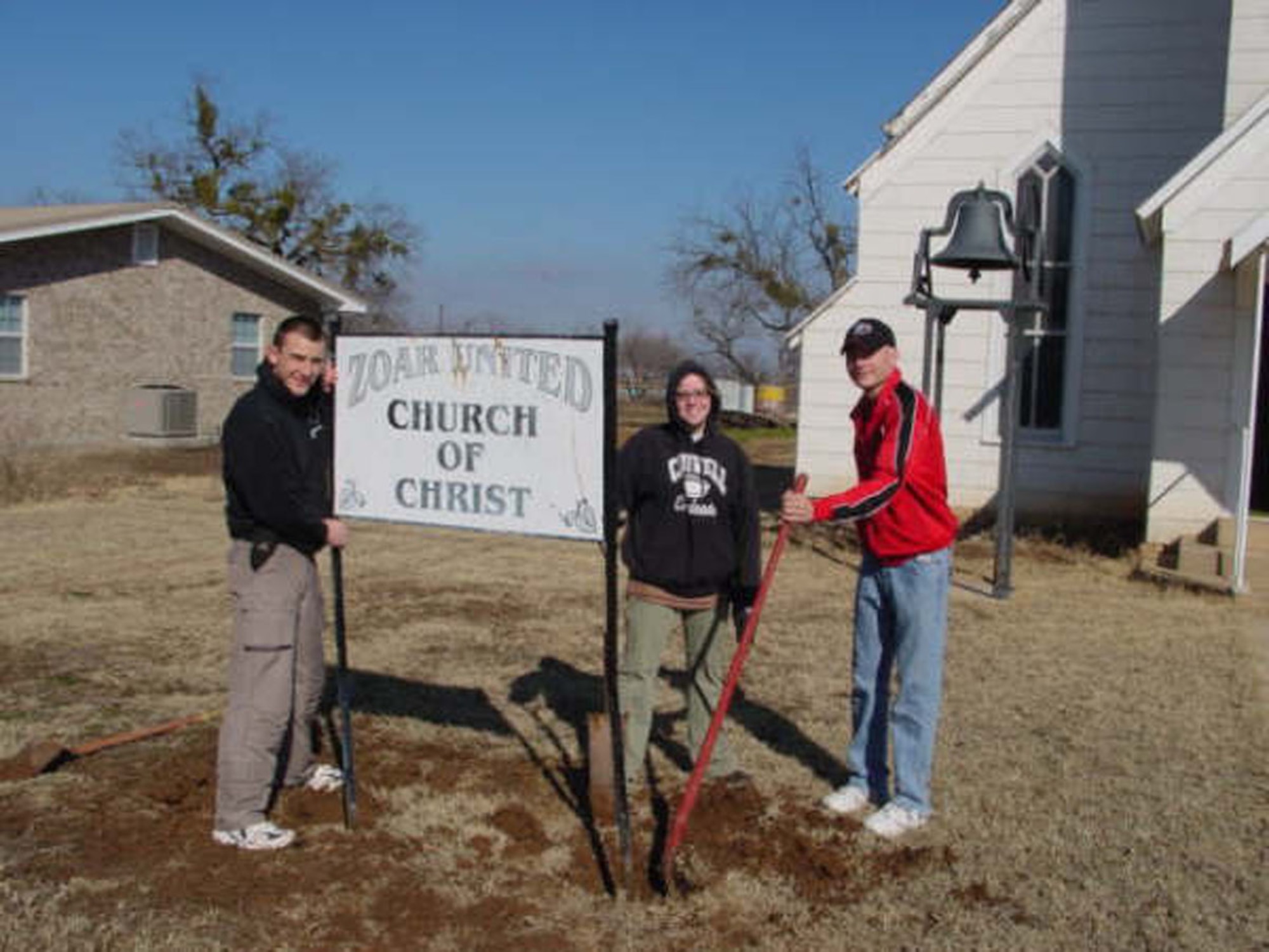 From left to right, Airman Kerry Dilis, Airman 1st Class Sherry Kedrowski and Airman Justin Cox, technical school students from Goodfellow, remove the old Zoar United Church of Christ sign. Students and permanent party from Goodfellow volunteered to fix up the historic church Feb. 3. (U.S Air Force photo by Tech. Sgt. Kelly Bales.)