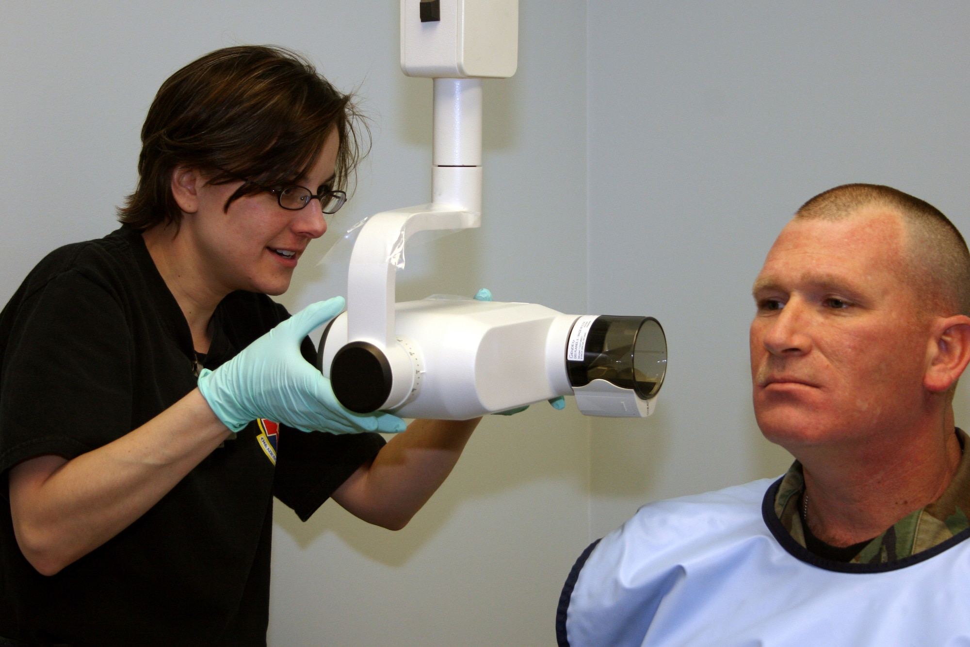 GRISSOM AIR RESERVE BASE, Ind.--Tech. Sgt. Nancy Johnson, left, positions the dental x-ray machine in order to take dental x-rays of Tech. Sgt. James Strode who just returned from inactive reserve status. Grissom conducts more than 50 physicals each unit training assembly. (U.S. Air Force photo/Senior Airman Omar Delacruz)