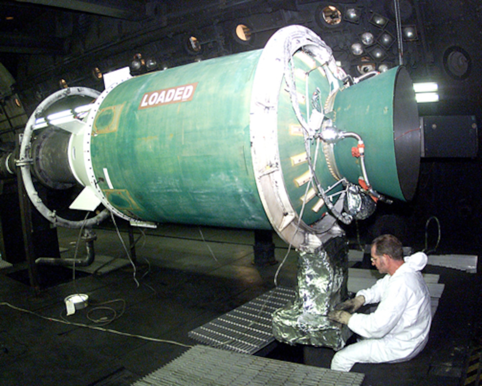 AEDC outside machinist J. R. Dunham prepares a Minuteman Stage III motor before testing in J-6 in 2003. Operators fired the randomly selected motor at a simulated altitude of 100,000 feet to qualify the motor’s production lot. The test confirmed contaminants in the propellant did not impact motor performance.