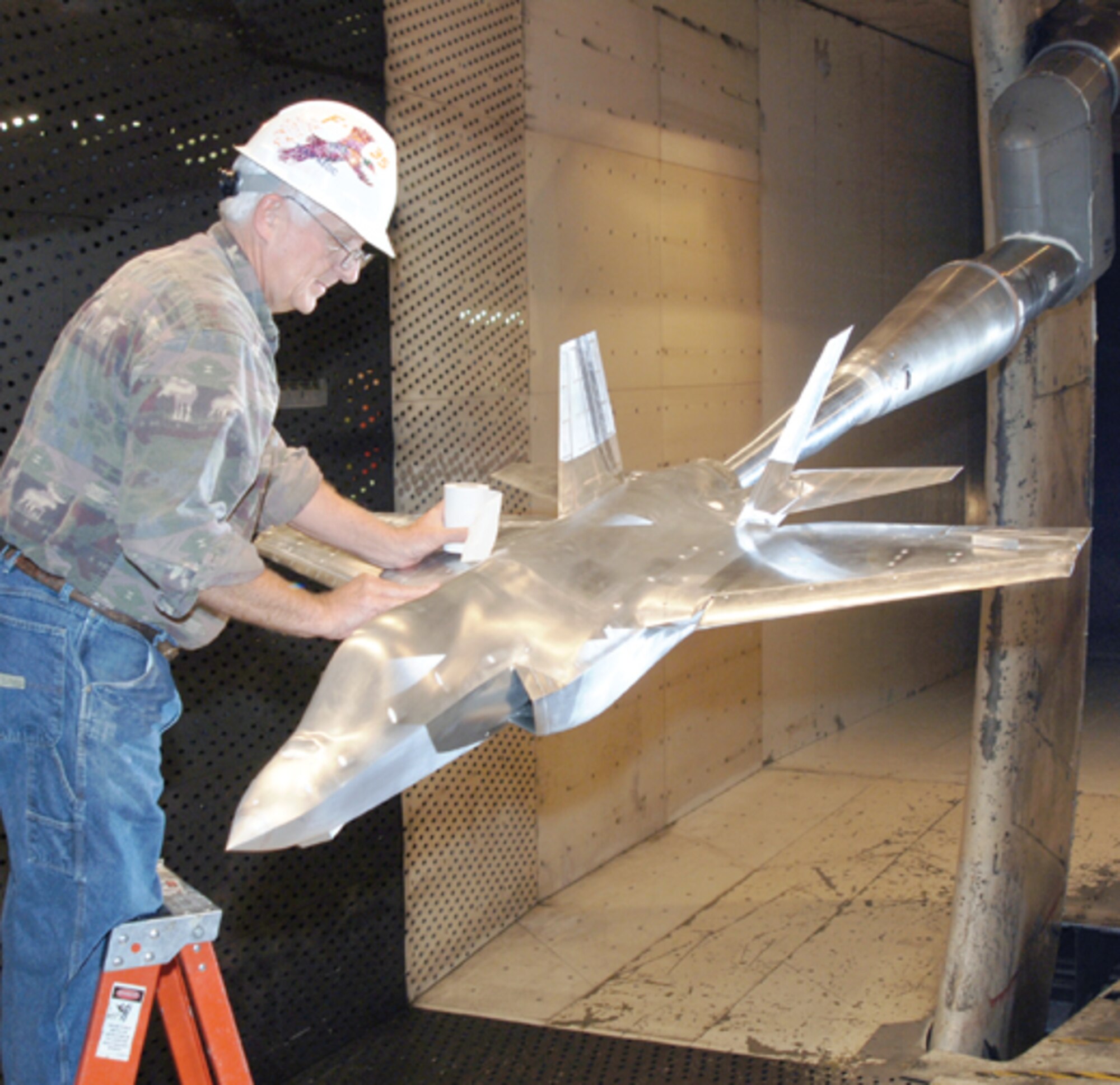 Jody Nunley, an ATK-GASL, Inc., craftsman, inspects a 12 percent scale model of the Navy’s version of the F-35 Lightning II at AEDC’s 16-foot transonic wind tunnel.
