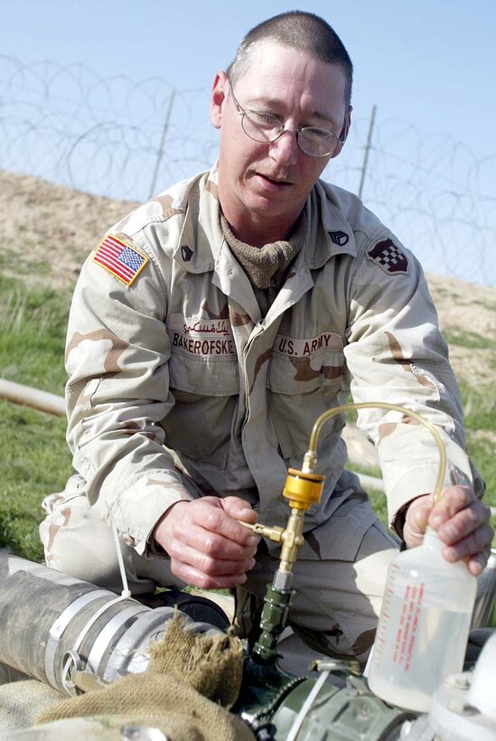 Army Staff Sgt. Dan G. Bakerofske, 978th Quartermaster  Company, pumps fuel into a plastic bottle so he can run tests on the fuel later  to make sure it's up to standard. Bakerofske is part of a forward logistical  element of U.S. soldiers supporting the Jordanian Medical Field Hospital in  Afghanistan's Balkh province. Photo by Sgt. Stephanie Hall, USA