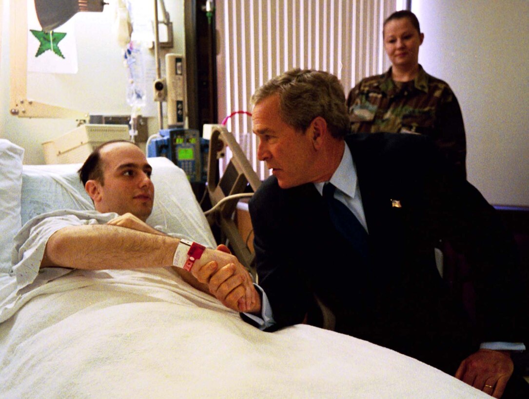 President George W. Bush meets with U.S. Army Specialist  Salvatore Cavallaro of East Providence, R.I., while visiting troops at Walter  Reed Army Medical Center in Washington, D.C., Friday, March 19, 2004. Also  pictured is Sergeant Gidget Rizzo. White House photo by Eric  Draper