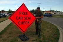 MINOT AIR FORCE BASE, N.D. – First Lt. Jonathan Zentner, 742nd Missile Squadron and base ground safety representative, sets up a road sign inviting passing motorists to receive a free child safety seat check-up here. National Child Passenger Safety week is from Feb. 11 to 17. (U.S. Air Force photo by Staff Sergeant Joe Laws)
