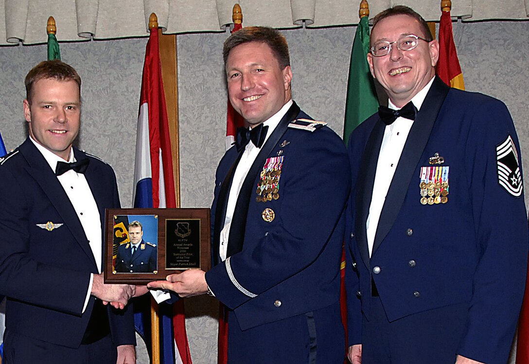 Maj. Patrick Isbell's performance during the recent Operational Readiness Inspection warranted his selection as the 80th Flying Training Wing's 2006 Instructor Pilot of the Year award. The 88th Flying Training Squadron officer was cited during the ORI for his exceptional leadership of the wing's weapon section, directly impacted the wing's overall Excellent rating. Maj. Isbell's commitment to excellence in training was evident in his implementation of Air Force weapons school concepts and academics in the squadron's training program. Also pictured, center, 80th FTW Commander Jeffrey Kendall and Chief Master Sgt. Norman Thierolf, 80th FTW superintendent. (U.S. Air Force photo/Harry Tonemah)