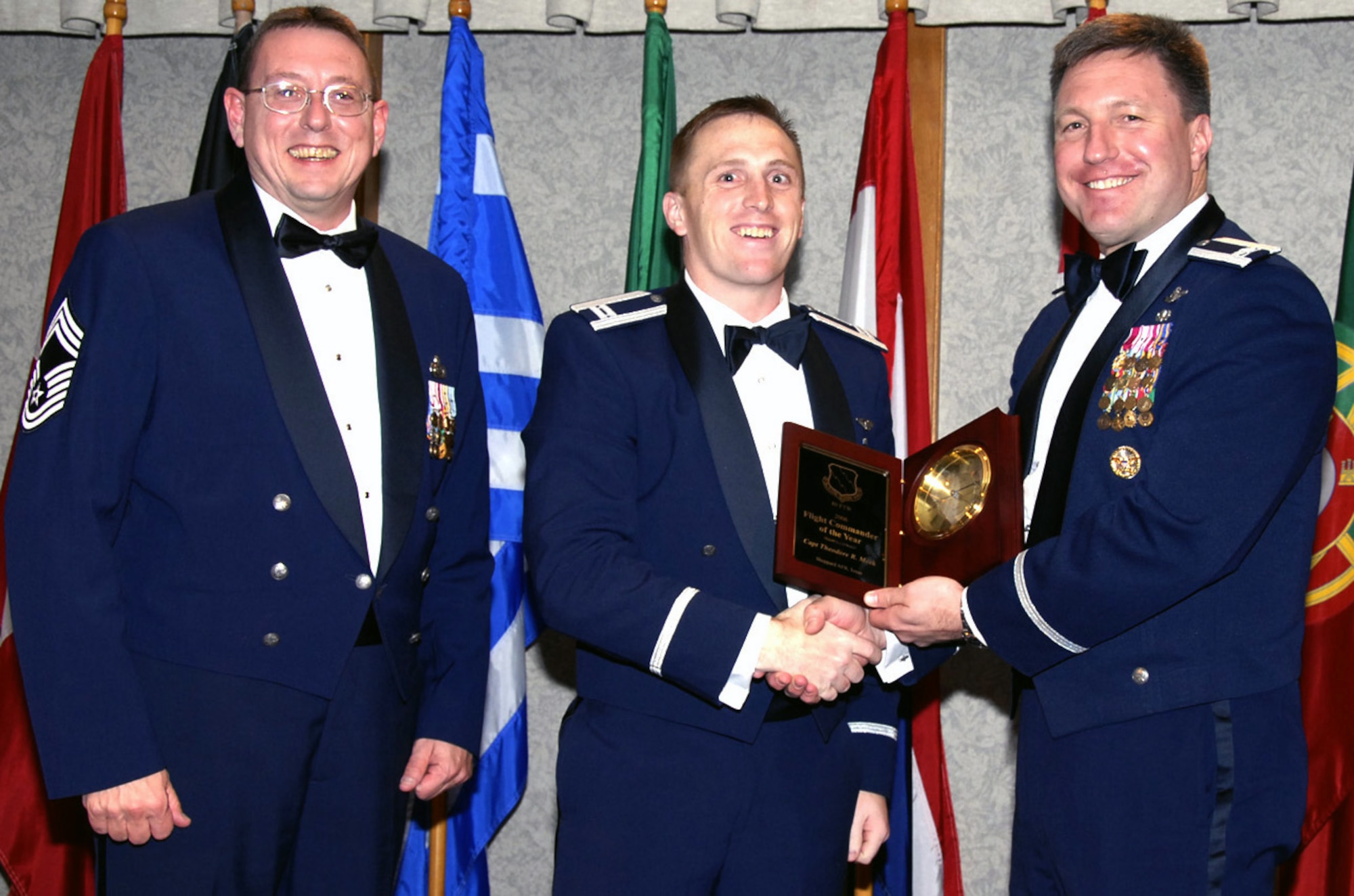 Capt. Ted Meek of the 88th Flying Training Squadron is the 80th Flying Training Wing's 2006 Flight Commander of the Year. Captain Meek distinguished himself in 2006 by producing zero findings during the Operational Readiness Inspection. He authored a new 62-page introduction to fighter fundamental threat guide used by 156 pilots to build a basis for warfighter knowledge. In his off-duty time, Captain Meek is a Boy Scout Troop Leader as well as a youth counselor at his church. Also pictured, left, Chief Master Sgt. Norman Thierolf, wing superindent, and 80th FTW Commander Col. Jeffrey Kendall. (U.S. Air Force photo/Harry Tonemah)