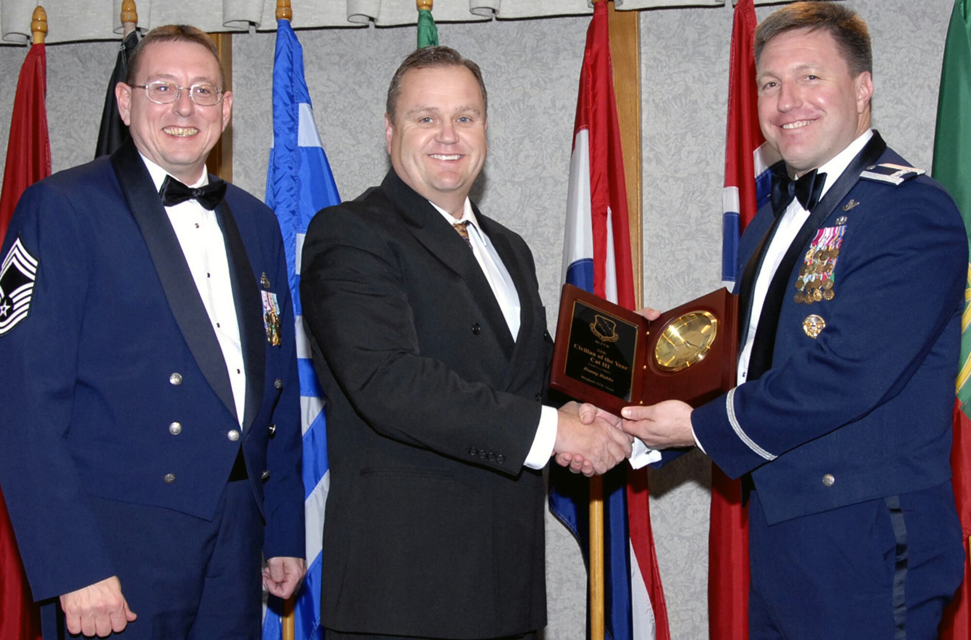 Danny Dabbs is the 80th Flying Training Wing's 2006 Civlian of the Year, Category III. Mr. Dabbs programmed 125 new civil engineering work orders and led the way in refurbishing the 89th and 90th Flying Training squadron's command section, including $77,000 renovations of the command sections' duty desks. Aside from the many renovation projects, Mr. Dabbs also improved himself professionally by completing 100 hours of environmental and computer training, as well as computer-aided drafting to provide the wing with an in-house drafting capability. Also pictured with Mr. Dabbs is, left, Chief Master Sgt. Norman Thierolf, the wing's superintendent, and 80th FTW Commander Col. Jeffrey Kendall. (U.S. Air Force photo/Harry Tonemah)