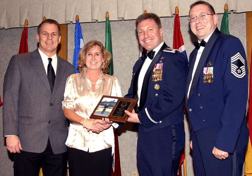 Michele Houck, second from left, is the 80th Flying Training Wing's Civilian of the Year, Category I. Mrs. Houck was recognized by wing leadership for her accomplishment of handling multiple schedules by prioritizing and rescheduling more than 1,800 appointments. She was also cited for implementing a new electronic staffing process for the 80th FTW as well as revising the wing administrative guide. Mrs. Houck is also busy with the local community, serving as the secretary of the Burkburnett High School Soccer Booster Club and pursuing a bachelor's degree. Also pictured with Mrs. Houck are her husband, Michael Houck, left, Col. Jeffrey Kendall, 80th FTW commander, and wing superintendent Chief Master Sgt. Norman Thierolf. (U.S. Air Force photo/Harry Tonemah)