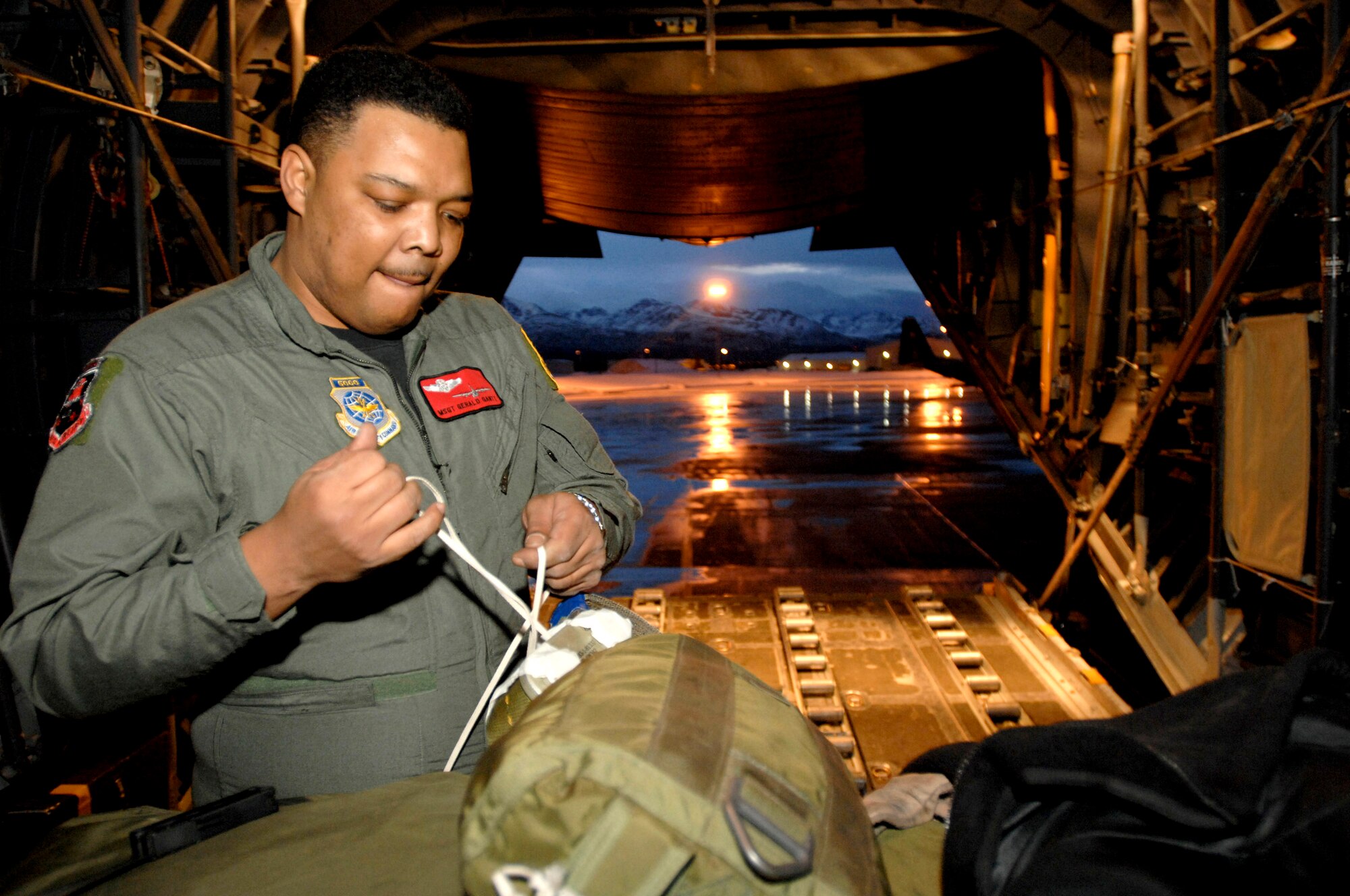 Master Sgt. Gerald Gantt attaches parachutes to a pallet in preparation for Feb. 1 training mission from Elmendorf Air Force Base, Alaska. Sergeant Gantt is a loadmaster with the 517th Airlift Squadron. The 517th AS will replace its fleet of C-130s with the C-17 Globemaster III in 2007. (U.S. Air Force photo/Tech. Sgt. Keith Brown) 
