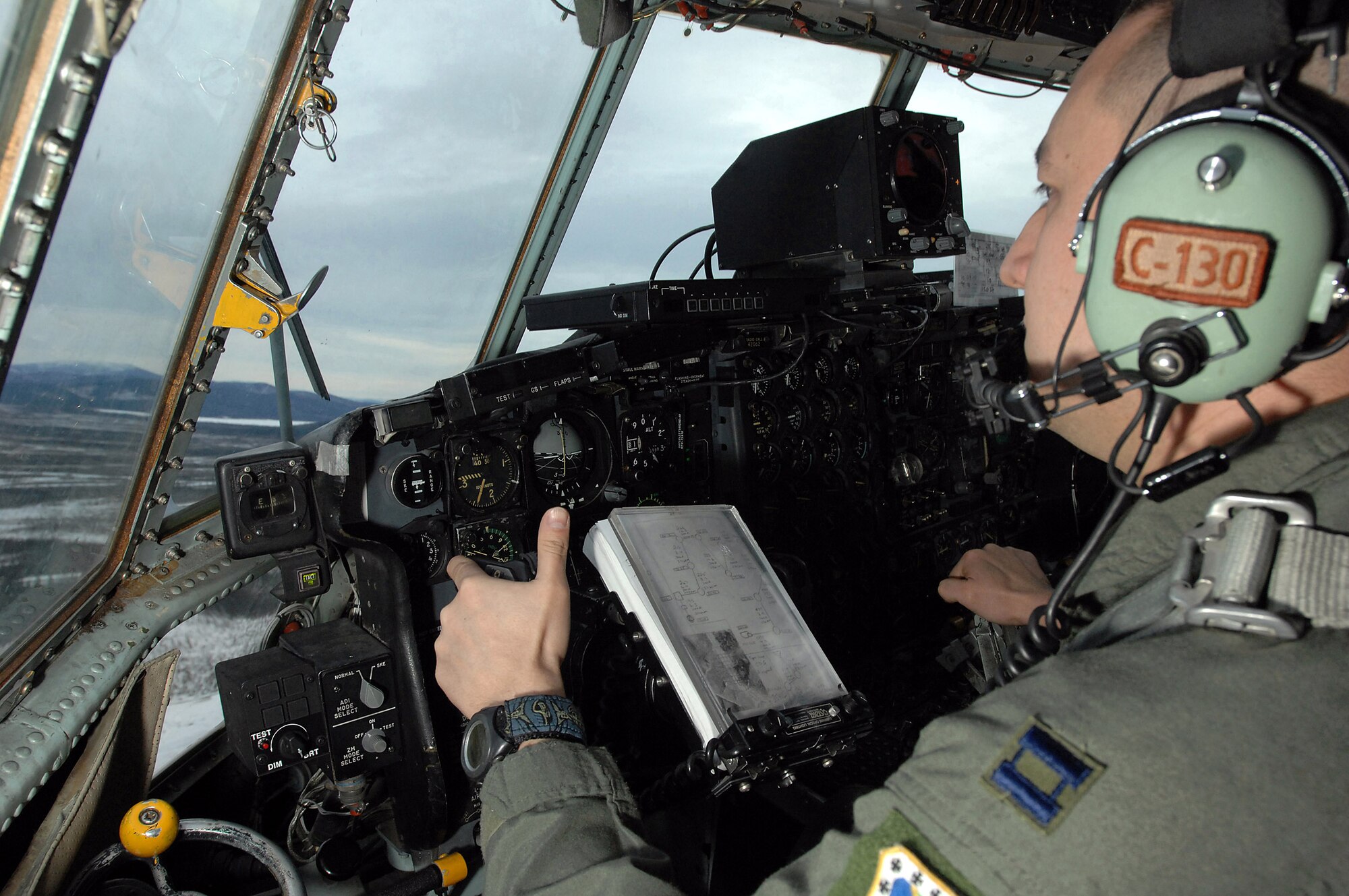 Capt. Joe Clancy keeps an eye out for simulated anti-aircraft fire during a training mission Feb. 1 over Alaska. Captain Clancey is a pilot for to the 517th Airlift Squadron from Elmendorf Air Force Base, Alaska. The 517th AS will replace its fleet of C-130s with the C-17 Globemaster III in 2007. (U.S. Air Force photo/Tech. Sgt. Keith Brown) 
