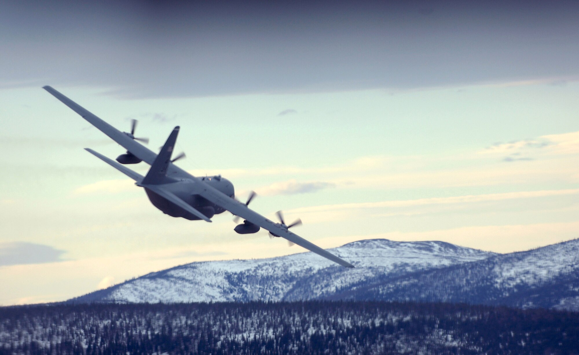 A C-130 Hercules flys a training mission that dropped pallets of simulated supplies at designated points in Alaskan Feb. 1. The C-130 belongs to the 517th Airlift Squadron at Elmendorf Air Force Base, Alaska. The 517th Airlift Squadron will replace its fleet of C-130s with the C-17 Globemaster III in 2007. (U.S. Air Force photo/Tech. Sgt. Keith Brown)
