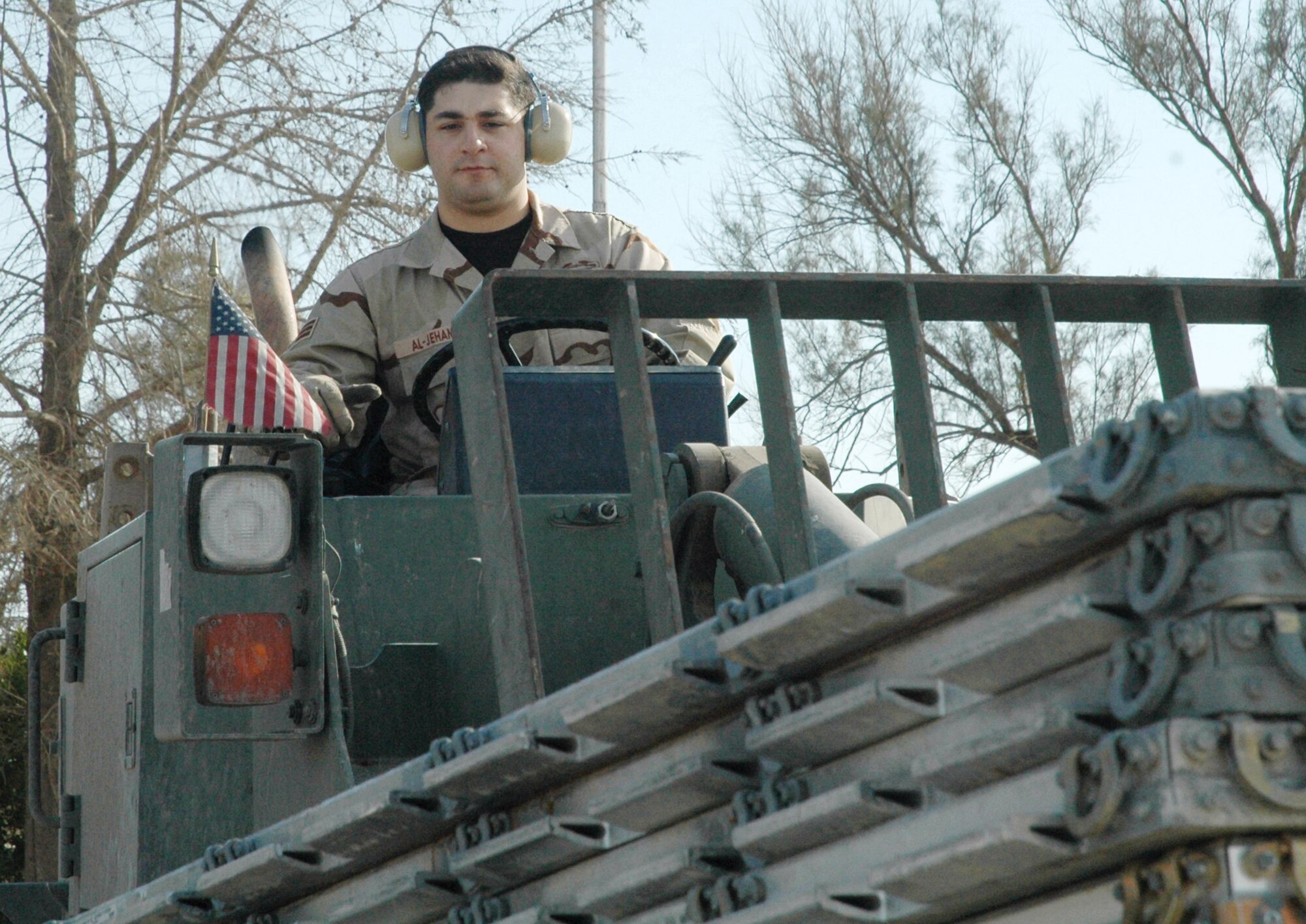 Senior Airman Jason Al-Jehani moves pallets in the cargo yard at Kirkuk Regional Air Base, Iraq, in January. Airman Al-Jehani was one of about 1,000 Army paratroopers who were airdropped into northern Iraq March 26, 2003. He is now a reservist assigned to the 39th Aerial Port Squadron at Peterson Air Force Base, Colo. Airman Al-Jehani is an air transportation journeyman deployed to the 506th Expeditionary Logistics Readiness Squadron. (U.S. Air Force photo/Tech. Sgt. Kevin Williams)