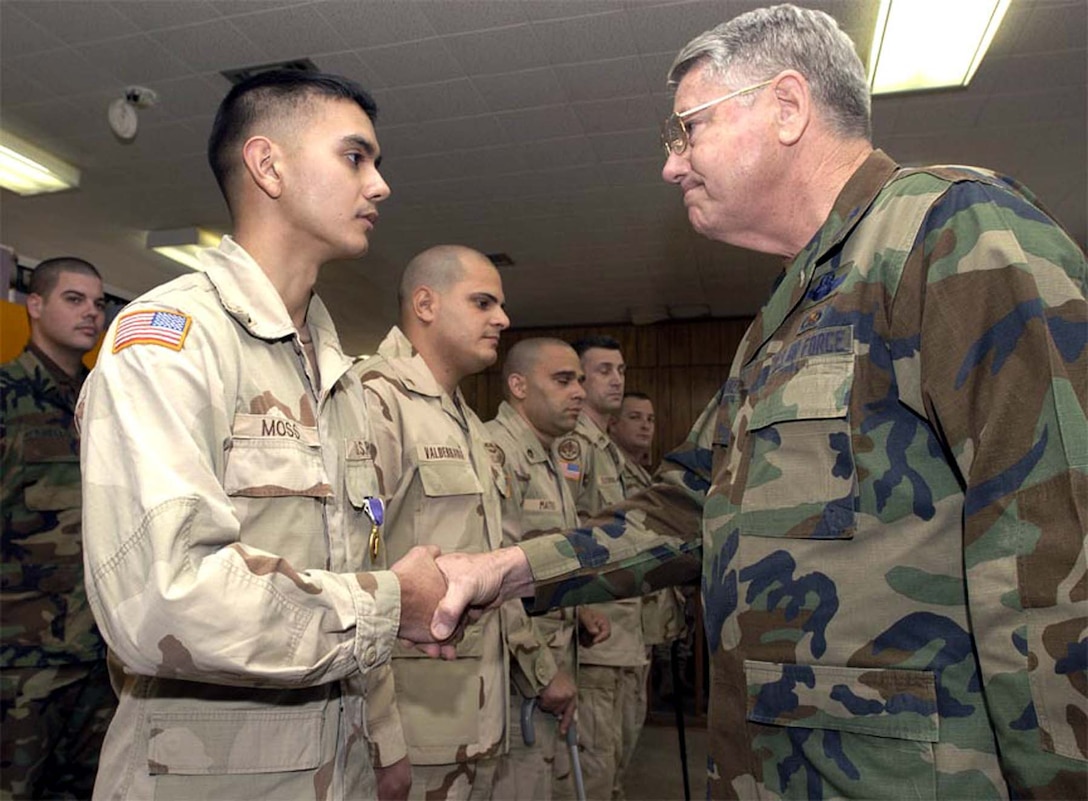 Spc. Matthew Moss (left) shakes hands with Maj. Gen. Douglas  Burnett, Florida National Guard adjutant general, after receiving a Purple  Heart during a ceremony at Fort Stewart, Ga., Jan. 30. Moss was wounded during  an explosion in Baghdad in November. Photo by Staff Sgt. Michael Southerland,  USA