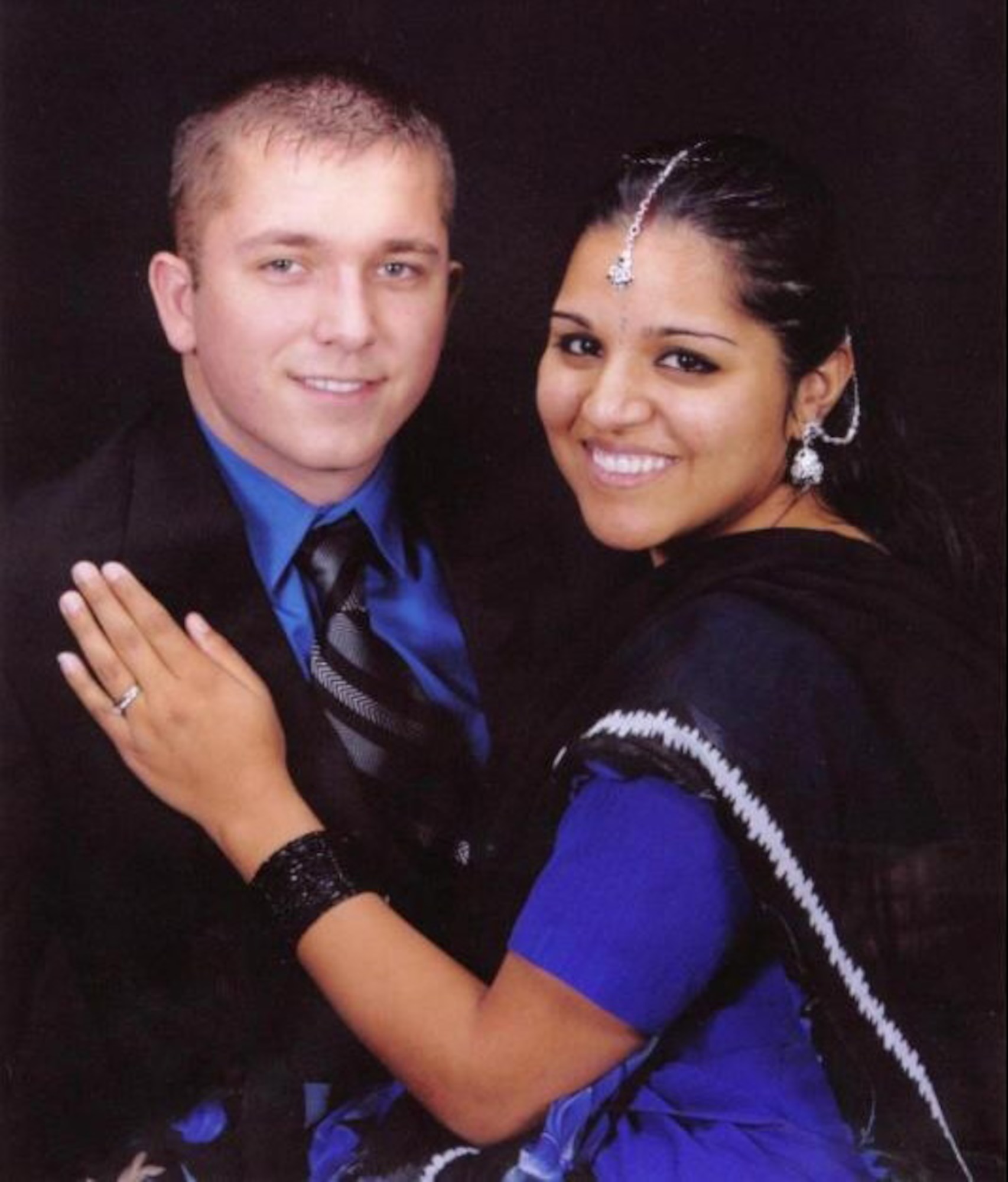 MOUNTAIN HOME AIR FORCE BASE, Idaho -- Senior Airman Steven Crawford, 366th Equipment Maintenance Squadron, and Airman 1st Class Paramjit Kaur, 366th Services Squadron, pose for a studio portrait.  "I believe love is the greatest feeling in the world and I still believe that," said Airman Kaur. "Since I've been with my husband, I've learned two people in love need to have an understanding and patience otherwise the relationship will lose its passion. Sometimes when people lose their patience or don't try to understand each other, regardless of how much they love one another, they tend to stray apart."  (U.S. Air Force photo)