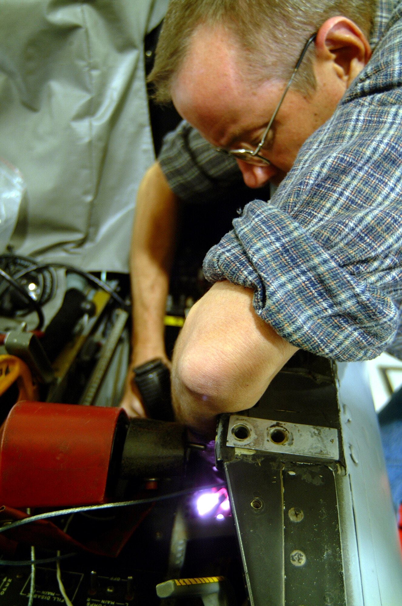 Air Reserve Technician Tech. Sgt. Paul Hanson uses an infrared "ray gun" to heat-shrink wire connectors during the installation of a new "smart" multi-function color display systems on an A-10 Thunderbolt II from the 442nd Fighter Wing at Whiteman Air Force Base, Mo.  Sergeant Hanson is an avionics specialist with the 442nd Aircraft Maintenance Squadron.  (U.S. Air Force photo/Maj. David Kurle) 