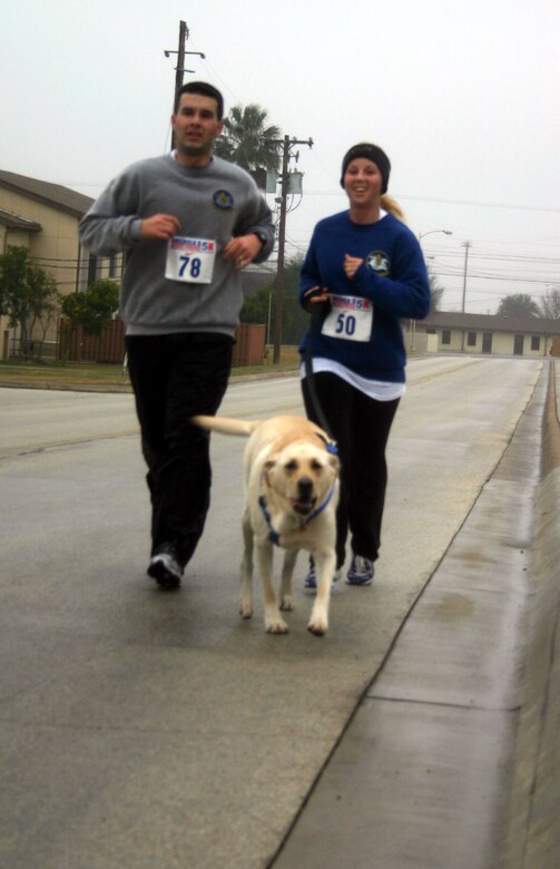 LAUGHLIN AIR FORCE BASE, Texas -- Jeff and Jessica Cameron, 85th Flying Training Squadron, complete the 5K run with their dog, Ace, with a time of 32 minutes, 37 seconds. First Lieutenant Jeff Cameron, Jessica and Ace were some of the participants in the Valentine 5K run/walk which began at 9 a.m. in front of the Losano Fitness Center Feb. 10.  The event was organized by the fitness center and was open to everyone.   (U.S. Air Force photo by Senior Airman Olufemi Owolabi)